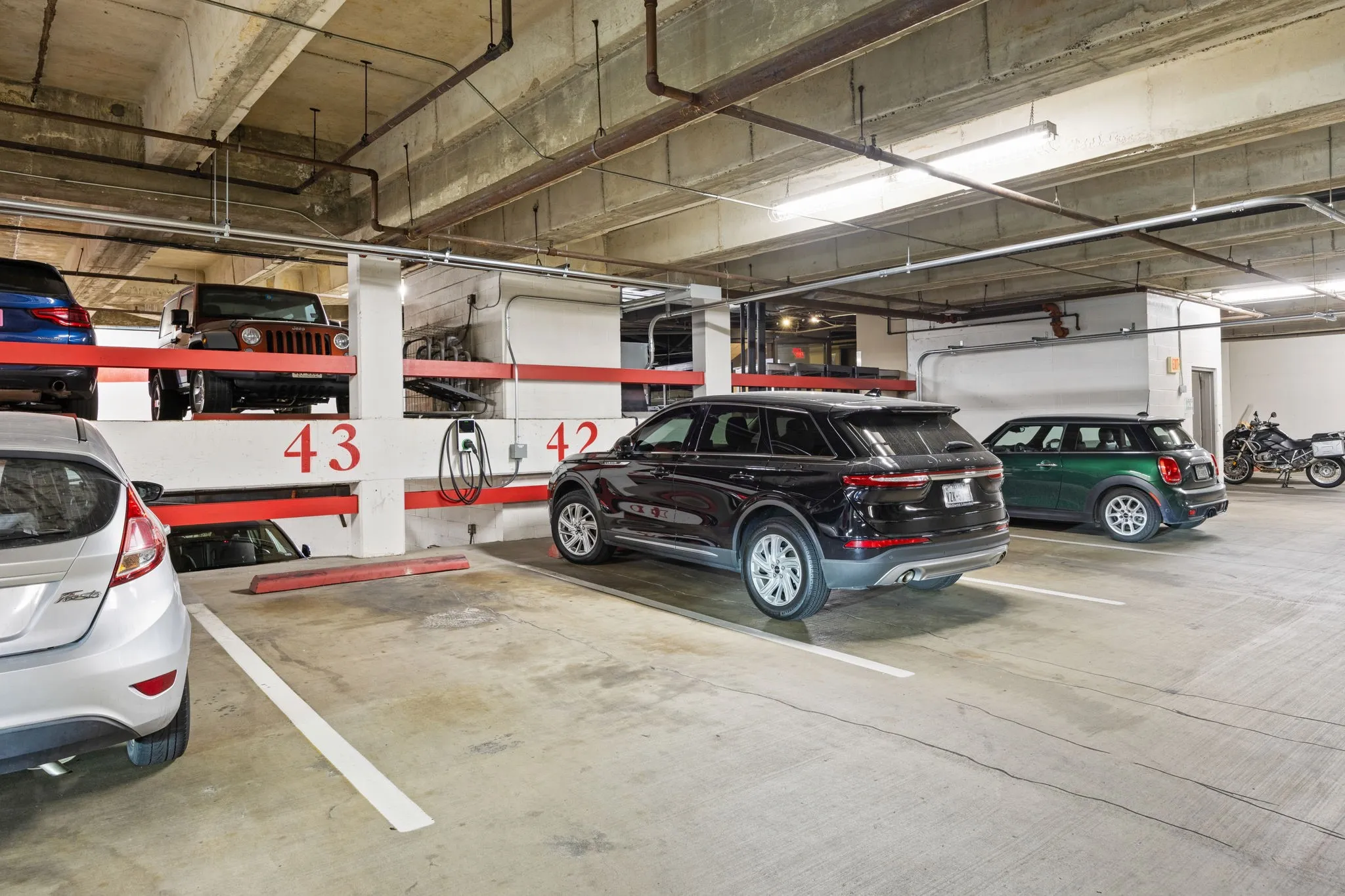 Your condo includes two assigned garage parking spaces, #42 and #43, with a conveniently located EV charging station positioned between the spaces—perfect for keeping your electric vehicle charged and ready to go.