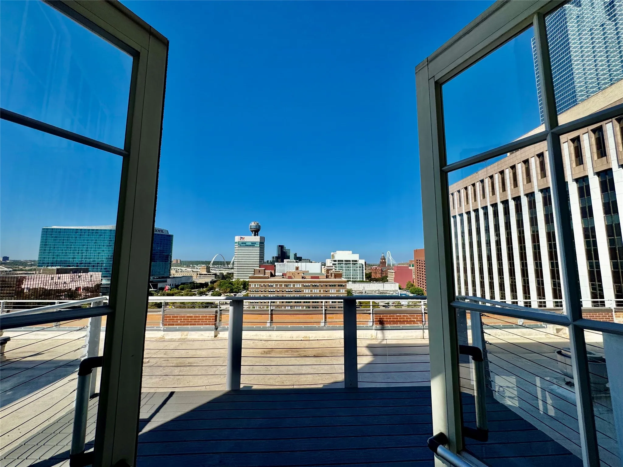 Rooftop deck featuring composite decking, cable railing system, and expansive urban scenery