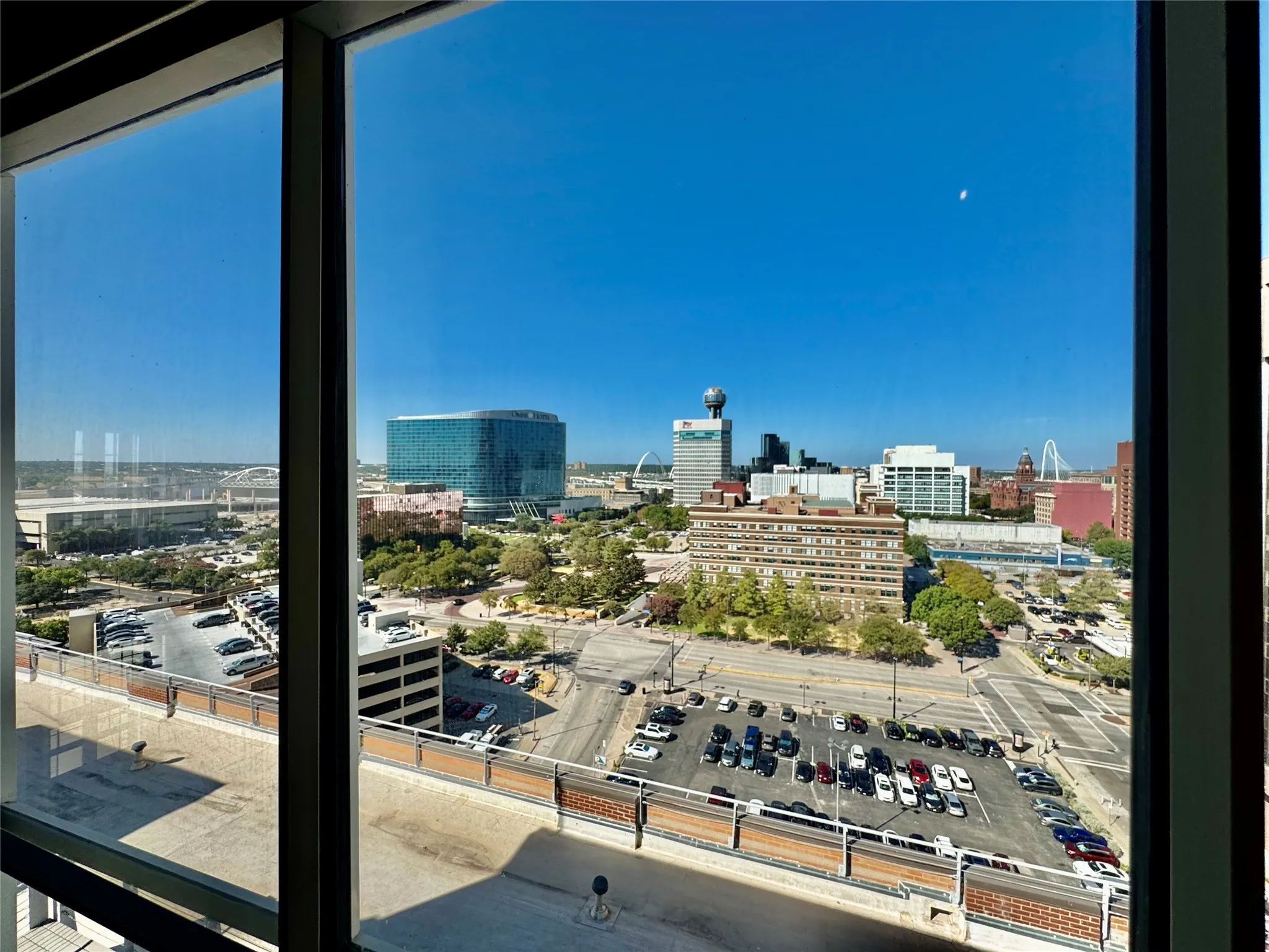 Expansive window framing a city skyline with prominent architectural structures and surrounding urban landscape