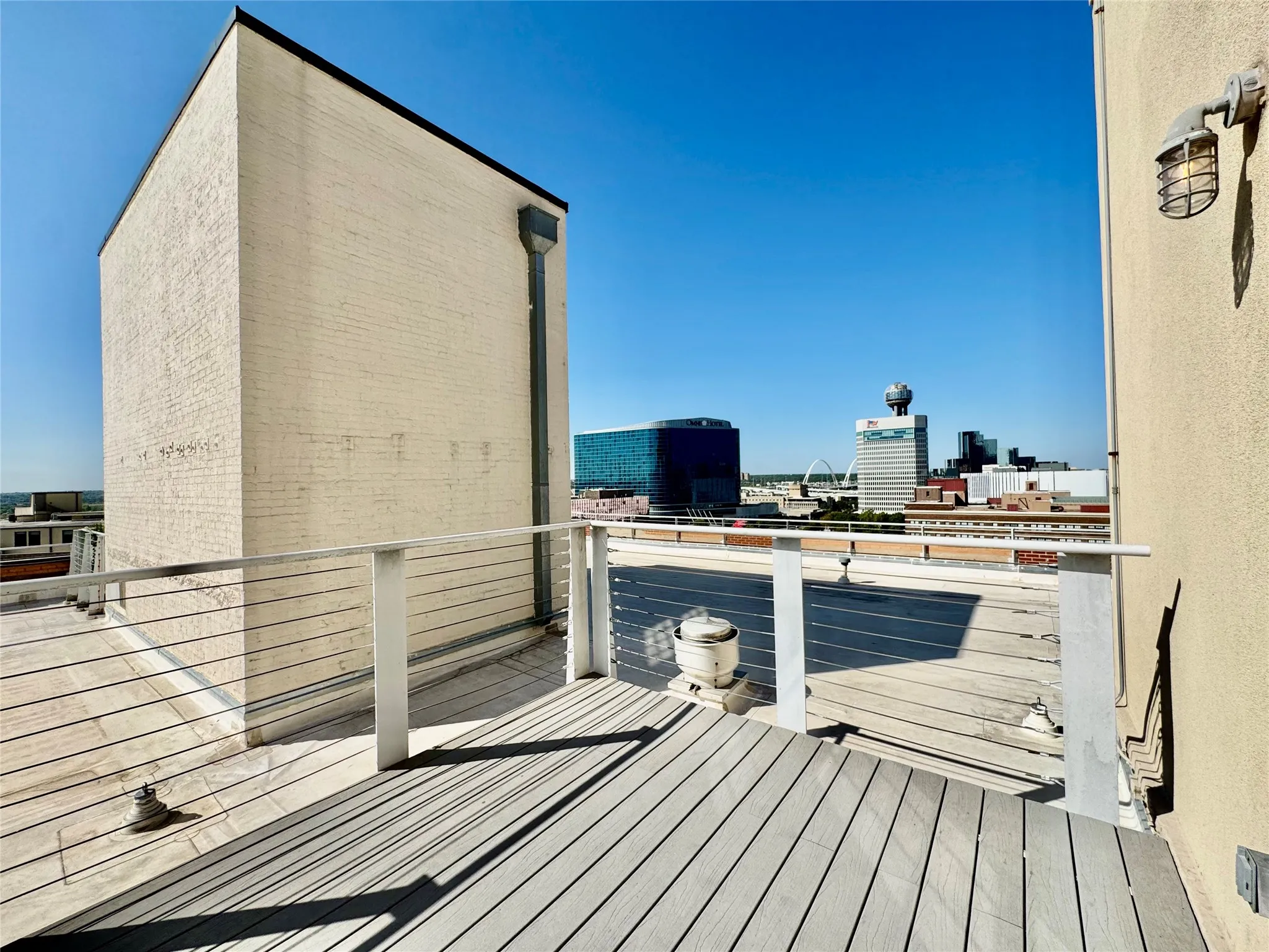 Rooftop deck featuring composite decking, cable railing, and urban skyline scenery