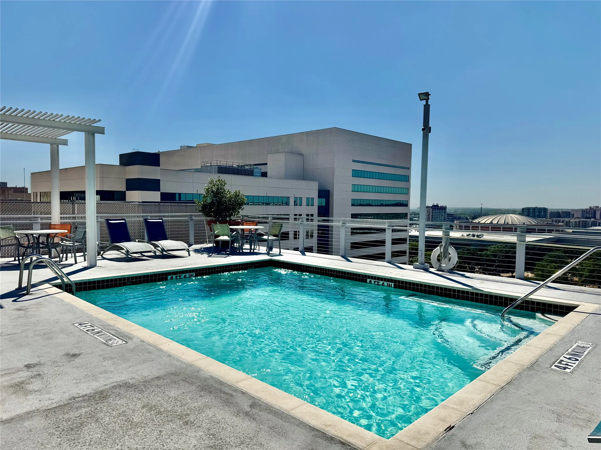 Rooftop swimming pool with integrated spa and metal handrails