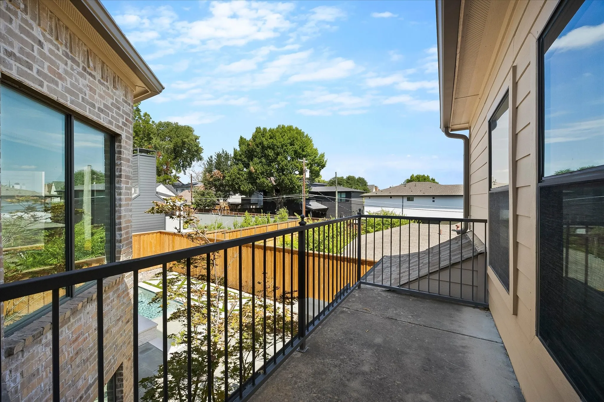 Balcony featuring a concrete surface, black metal railings, and views of the surrounding area