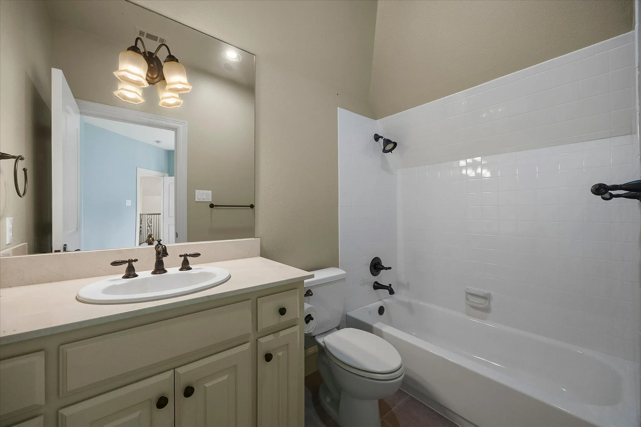 Vanity with integrated sink, bronze-finish faucet, and coordinating cabinet hardware