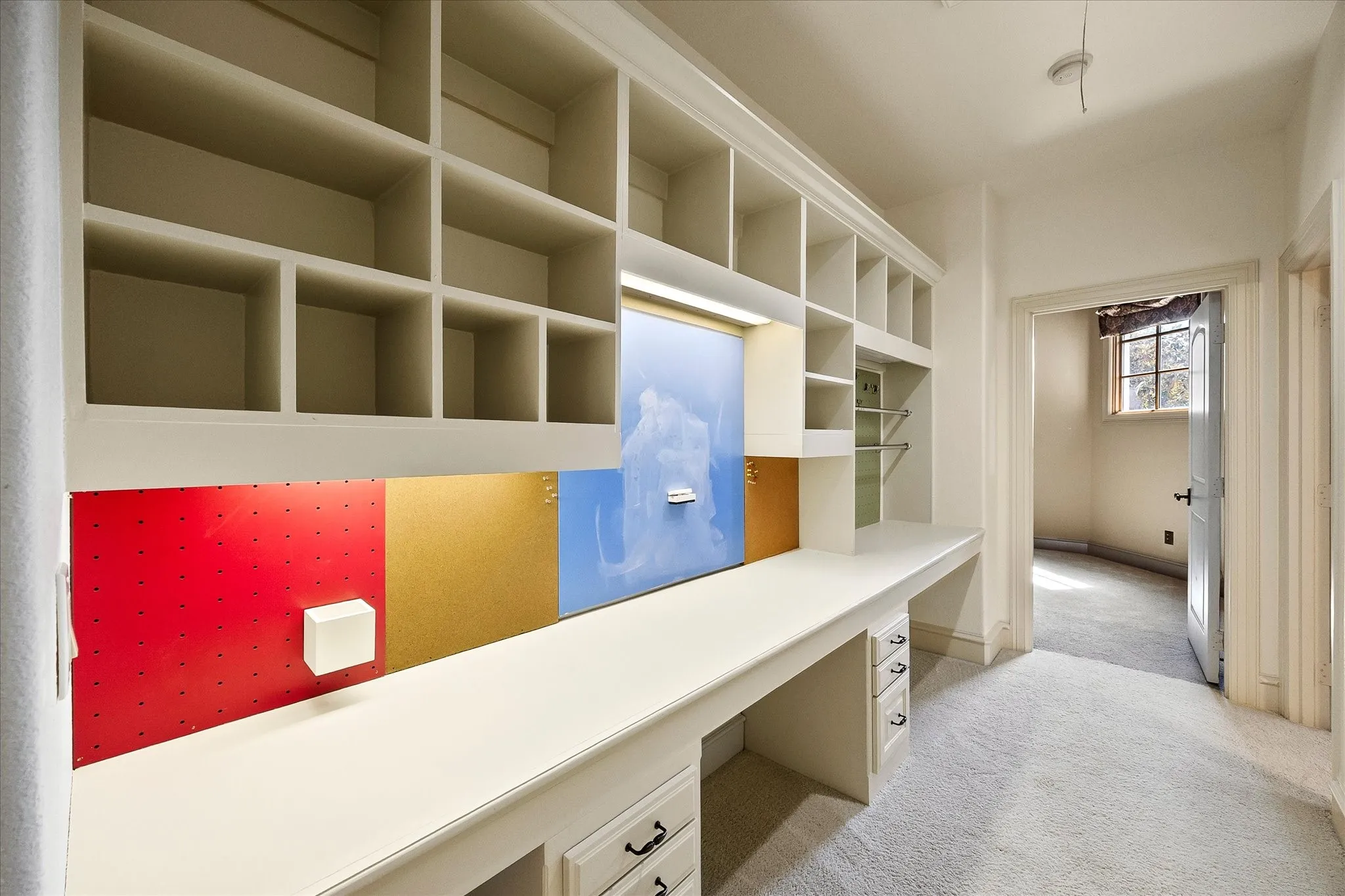 Built-in desk with integrated shelving, under-cabinet lighting, and integrated storage drawers