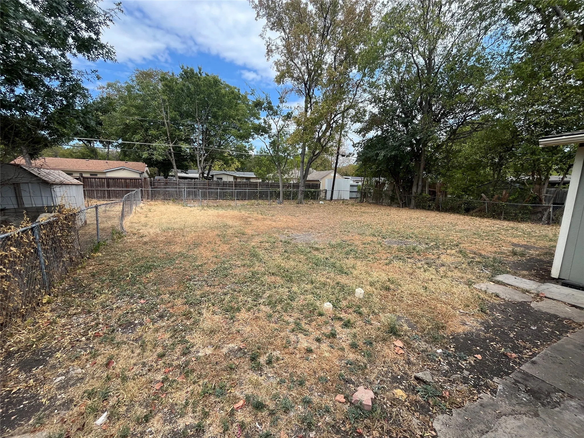 Expansive, level lot with mature trees and perimeter fencing