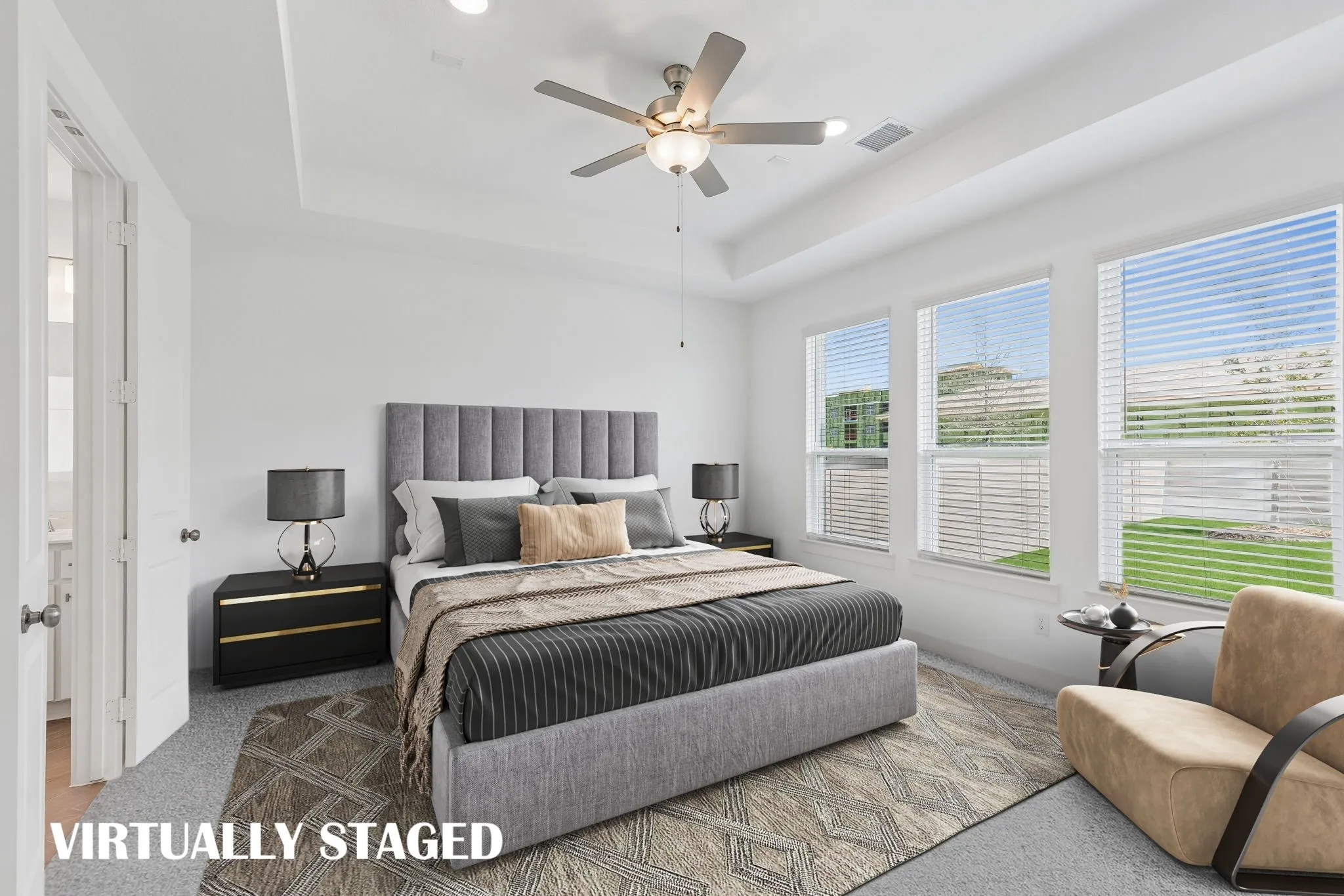 High ceilings, plush carpet and a wall of windows create a peaceful and relaxing owner's suite.  VIRTUALLY STAGED
