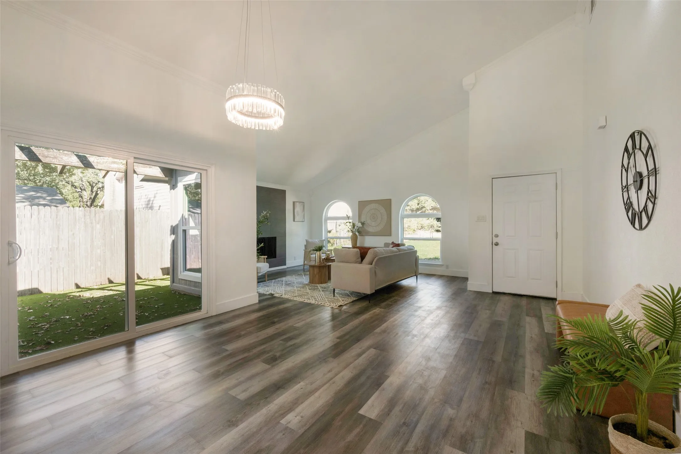 Vaulted ceilings and wood-finish flooring complement the interior, featuring arched windows and a fireplace