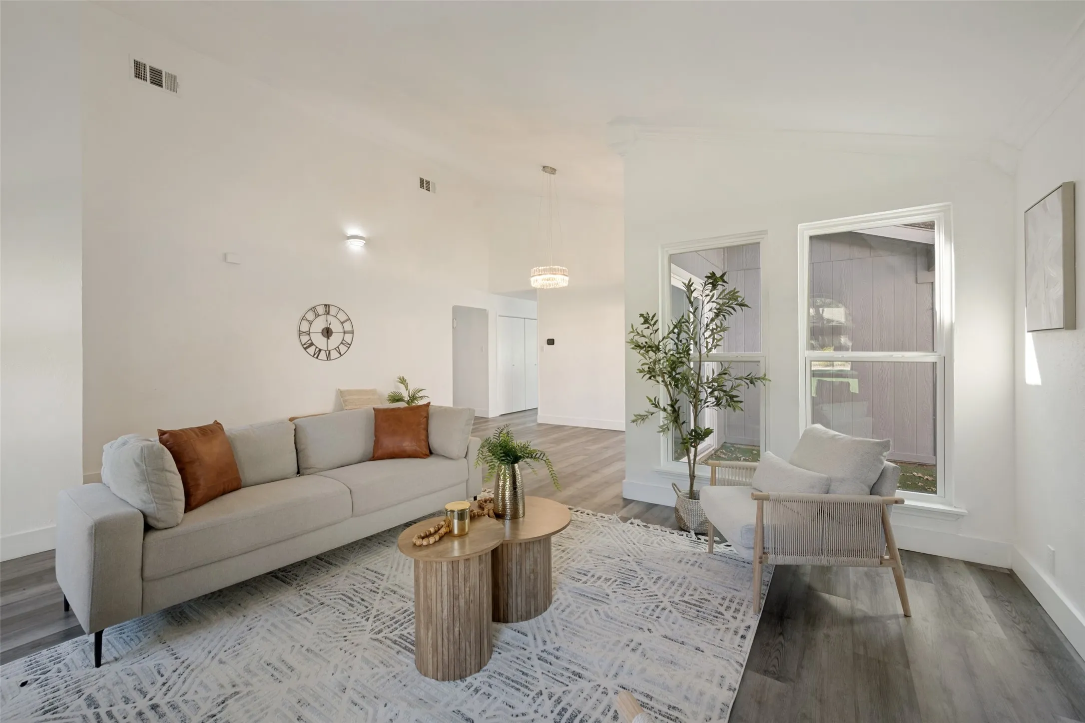 Spacious interior with vaulted ceilings, wood-finish flooring, recessed lighting, and large windows
