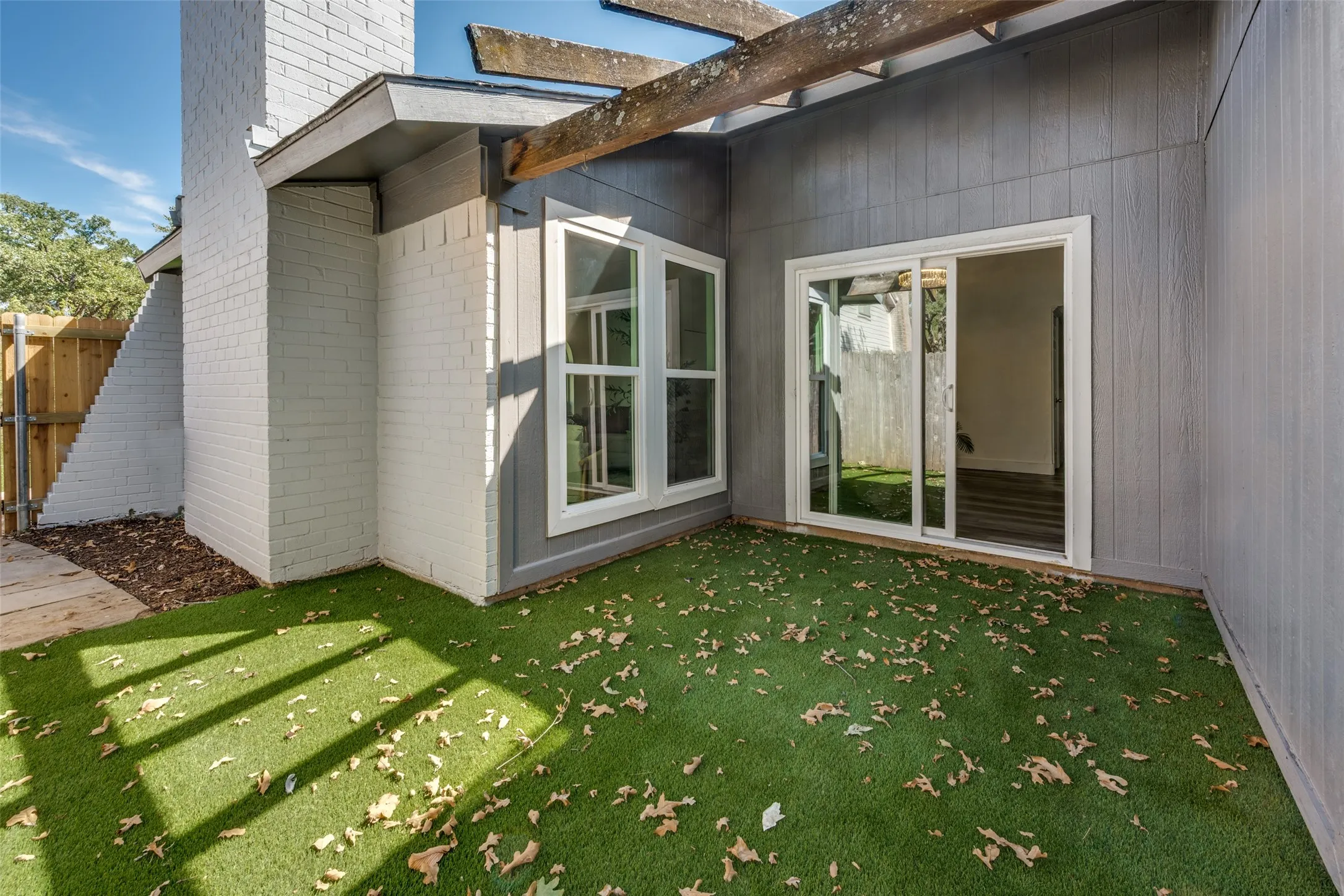 Patio off of the living room featuring artificial turf