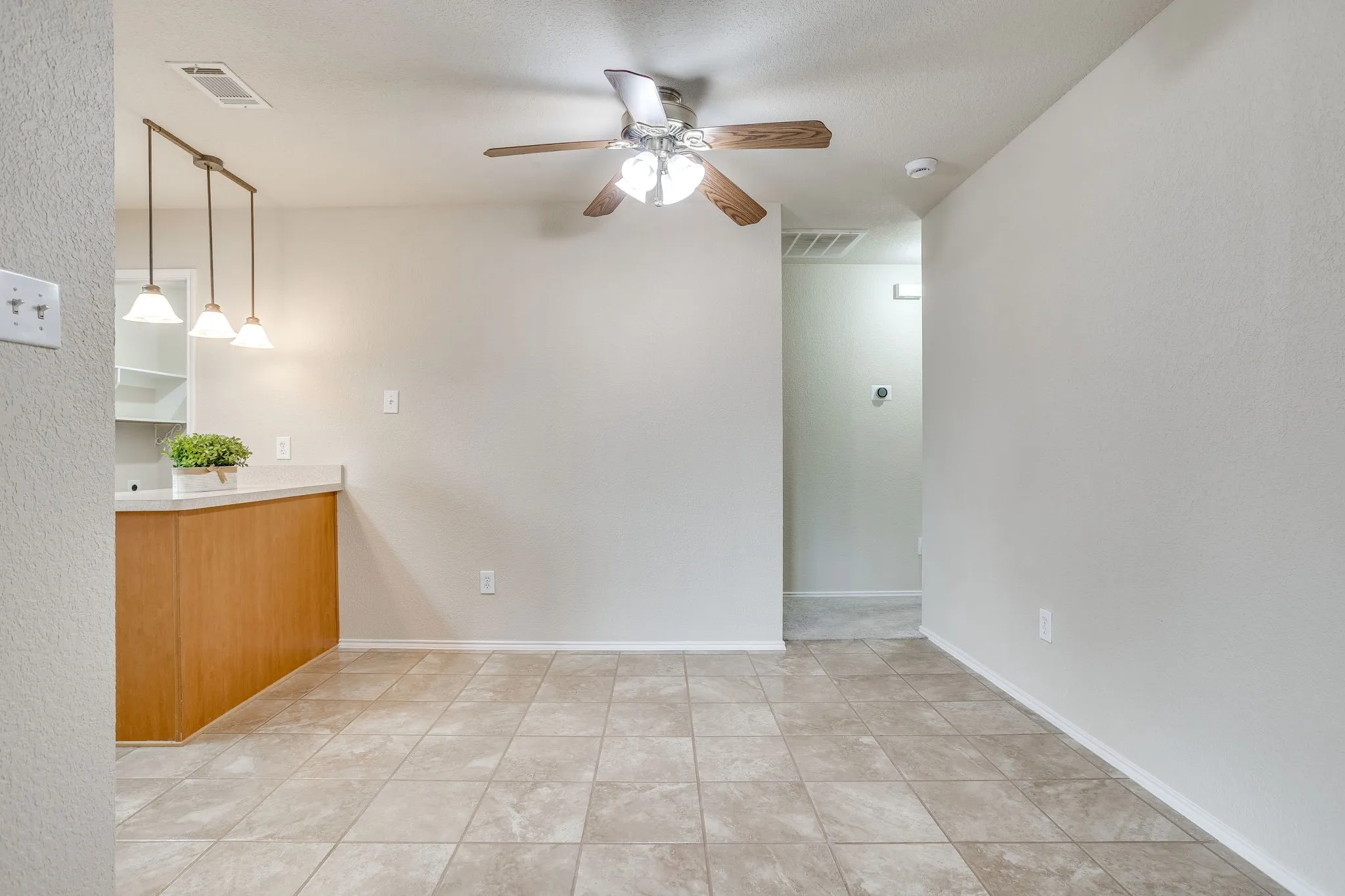 Tile flooring throughout, with a ceiling fan light fixture