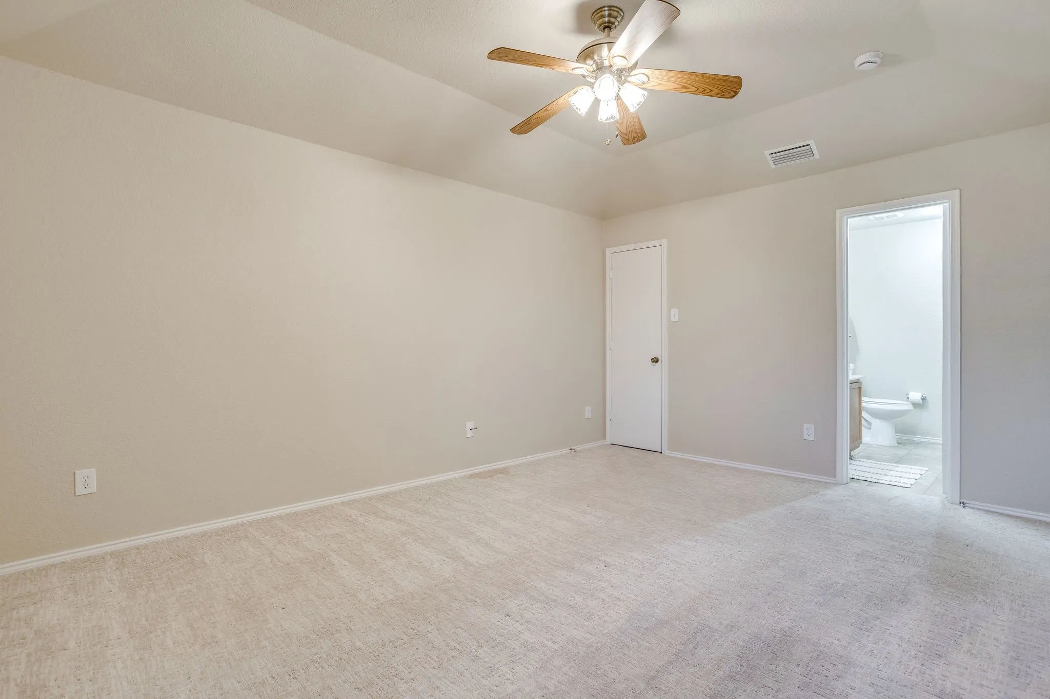 Vaulted ceiling with a ceiling fan, neutral carpeting, and light-toned wall paint