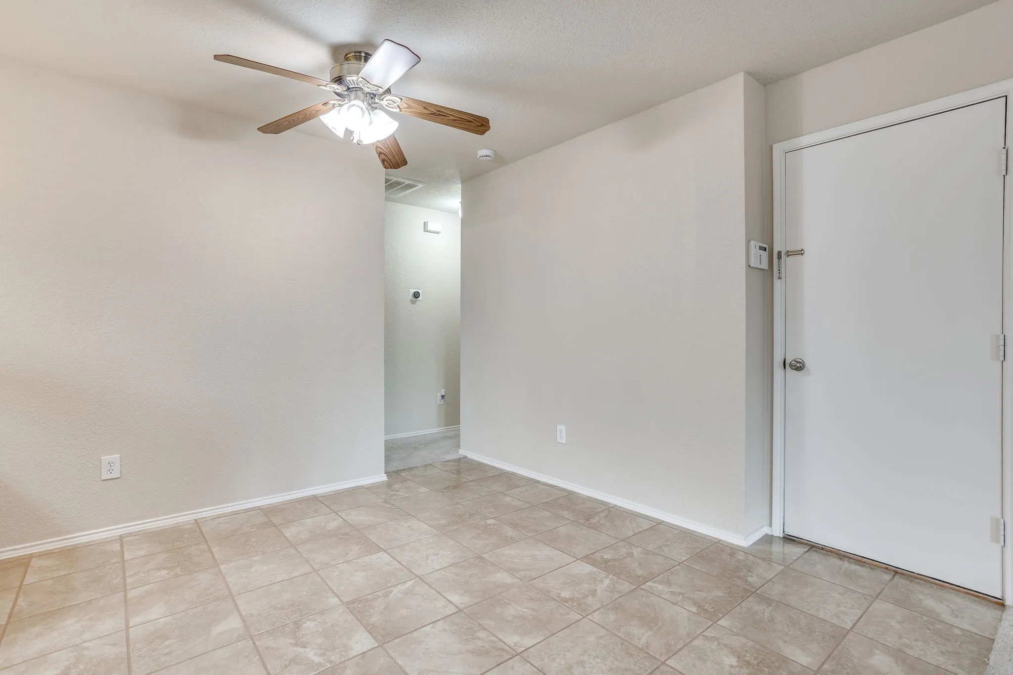 Neutral tone tile flooring with a flush ceiling fan