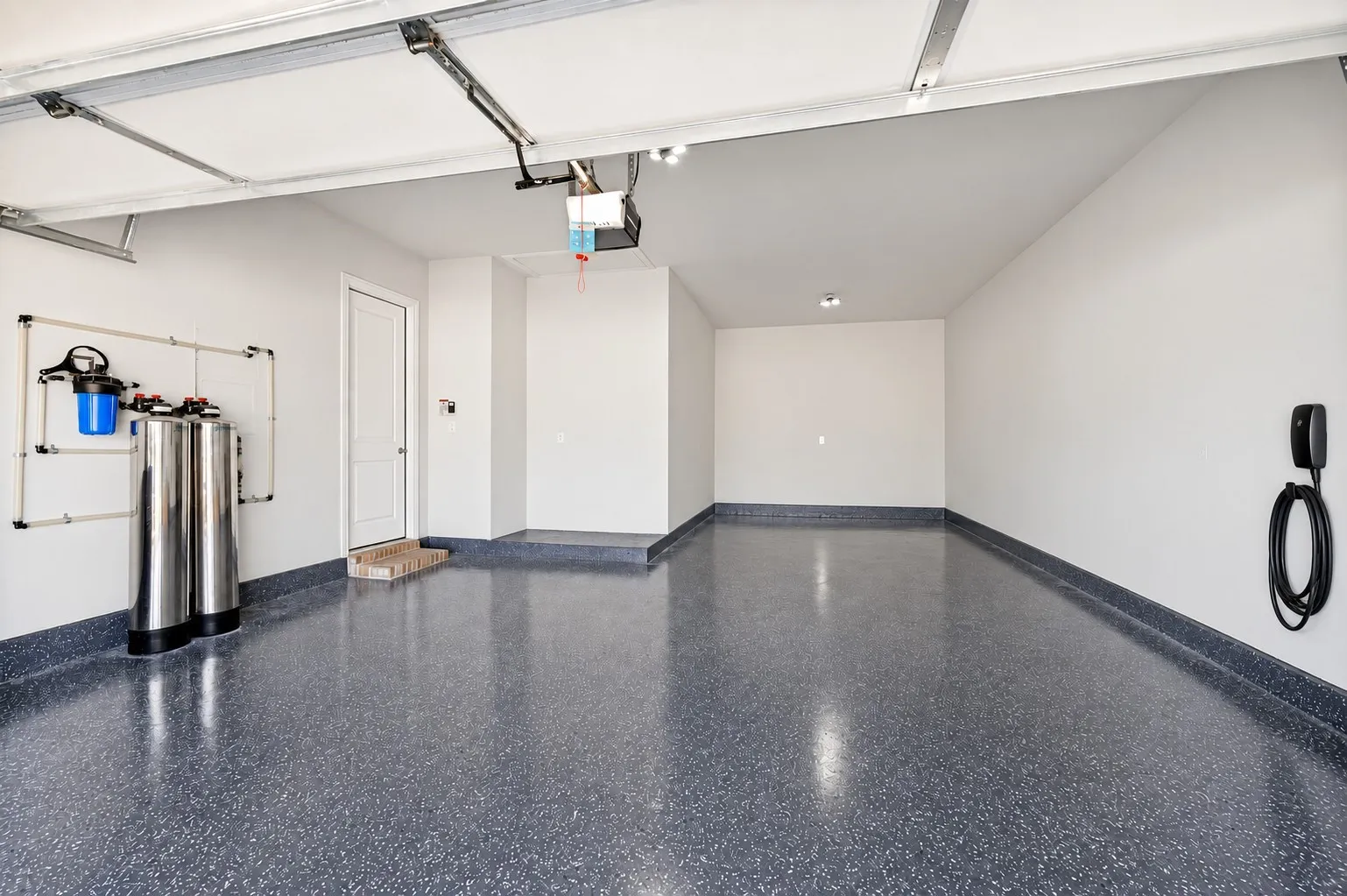 Spacious 3-car tandem garage with epoxied floor and electric car charger.