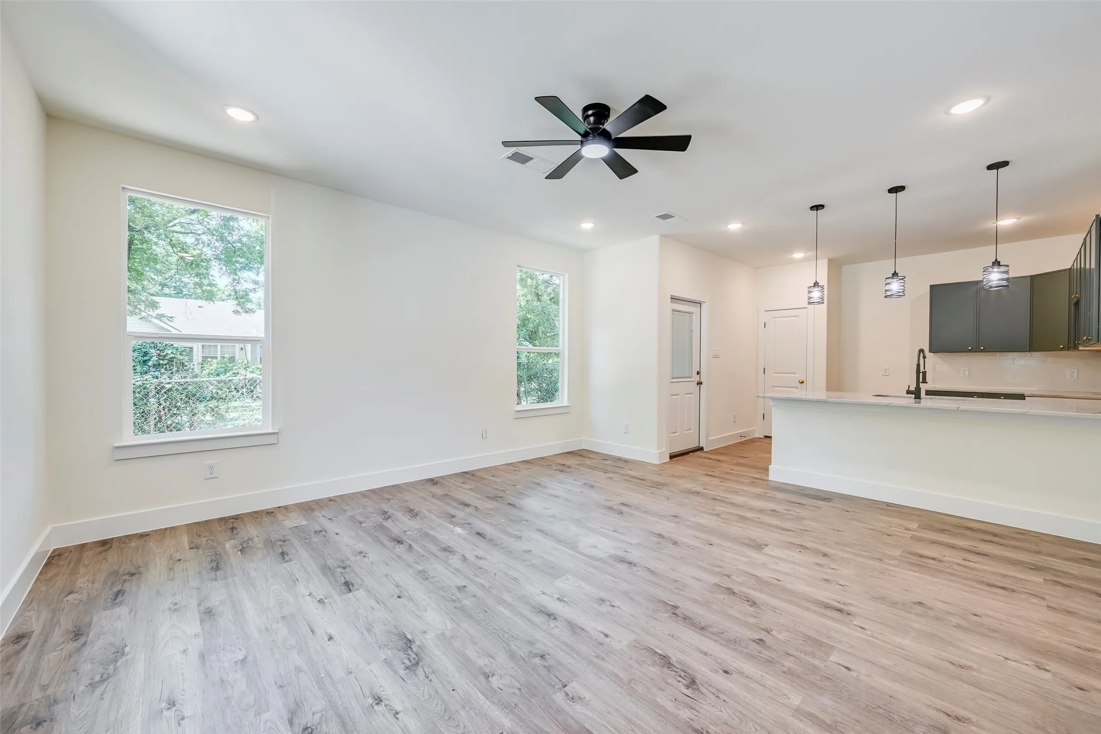 Open-concept living space featuring wood-finish flooring, recessed lighting, and a contemporary ceiling fan