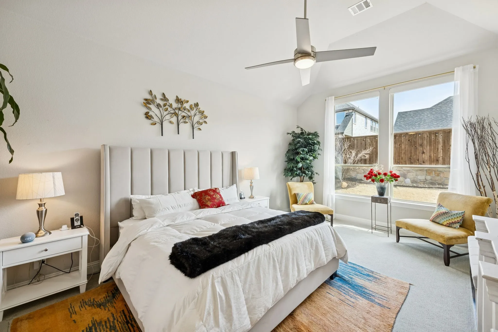 primary bedroom with tall windows and ceiling fan