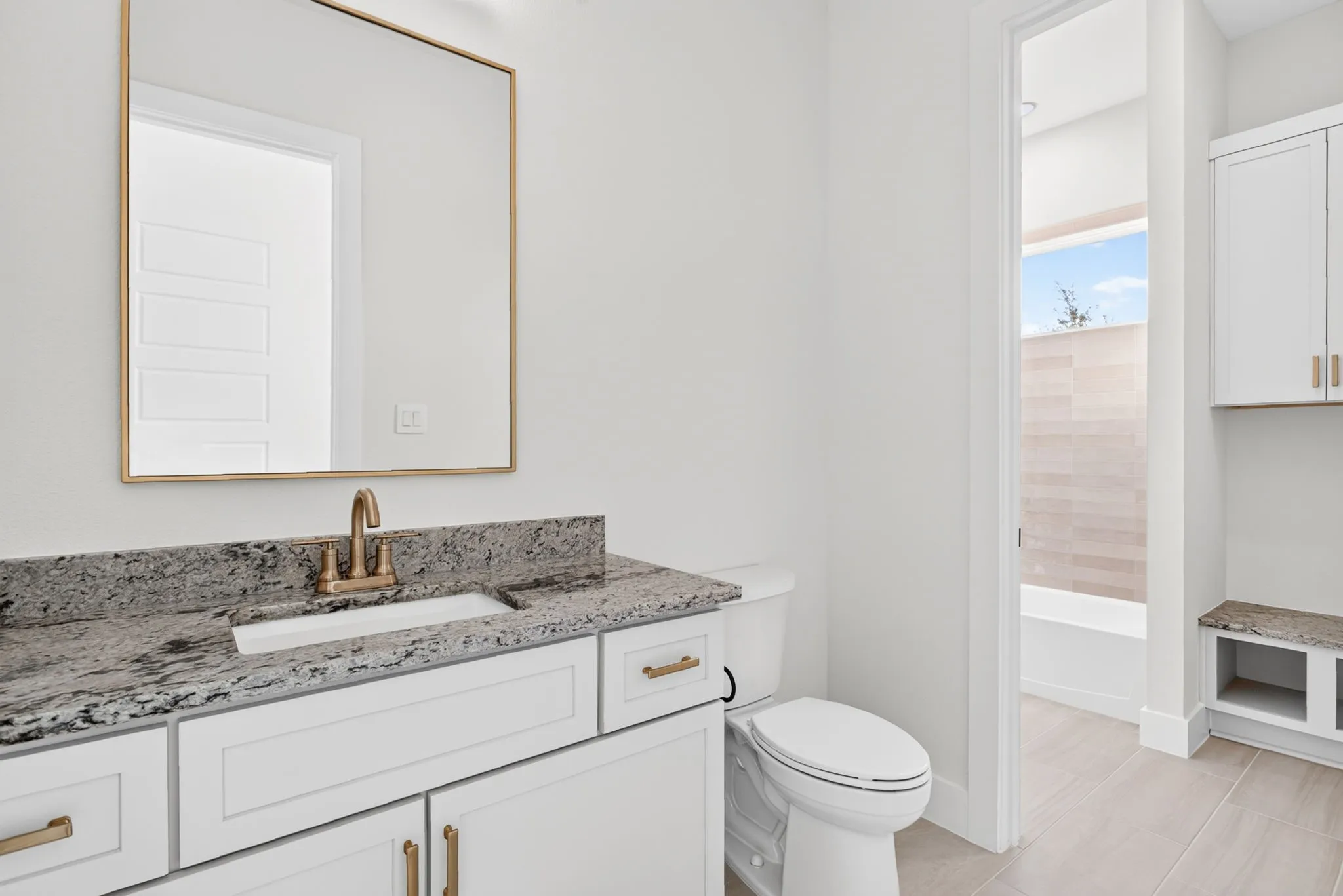 Two bedrooms connect view a jack and jill bathroom - with separate vanities, storage bench and toilet.
