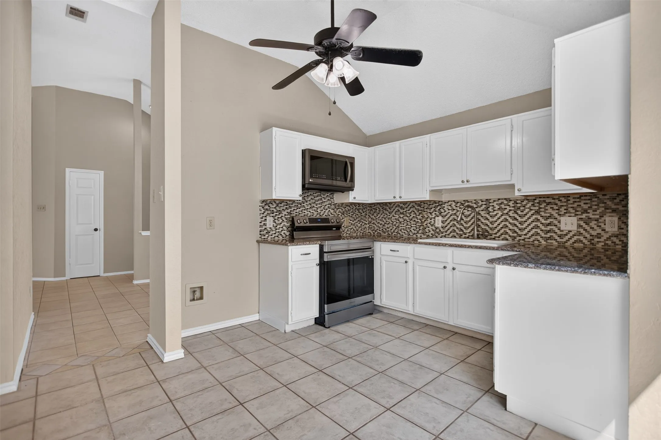 High ceilings, farmhouse sink and stainless steel appliances.
