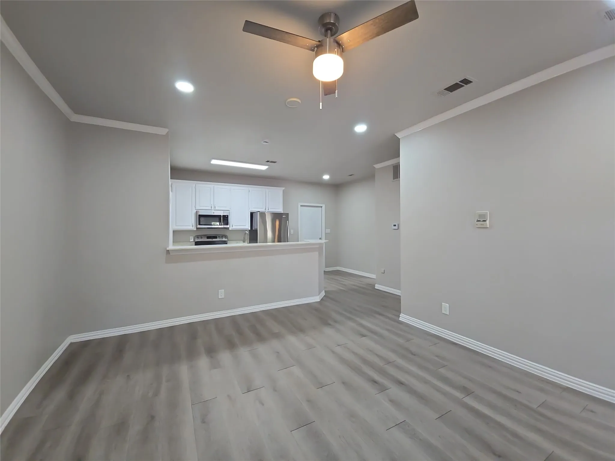 Wood-finish flooring throughout, complemented by white trim and crown molding