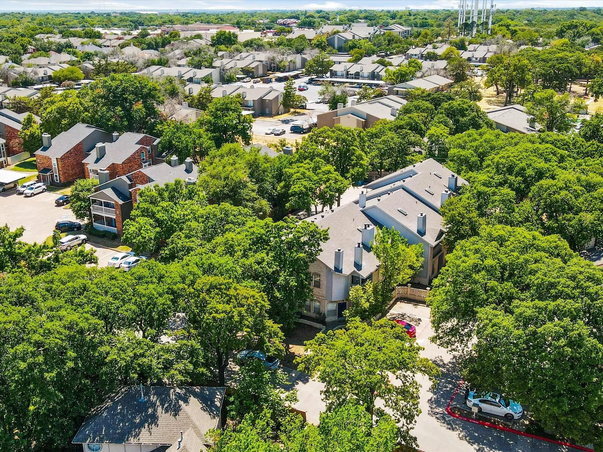 Expansive property featuring mature trees, multiple buildings, and surface parking areas