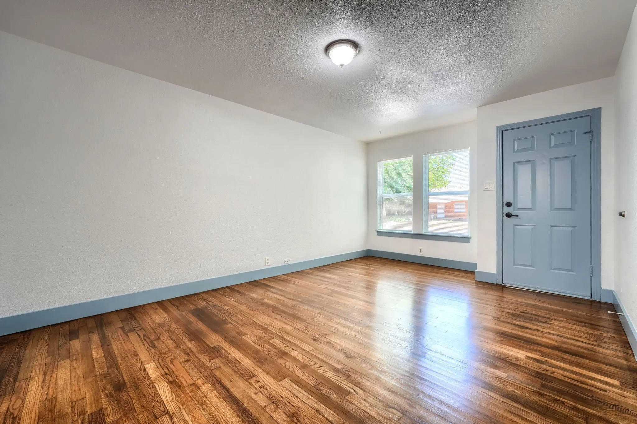 Wood-finish flooring, white walls, and a blue trim accent the space