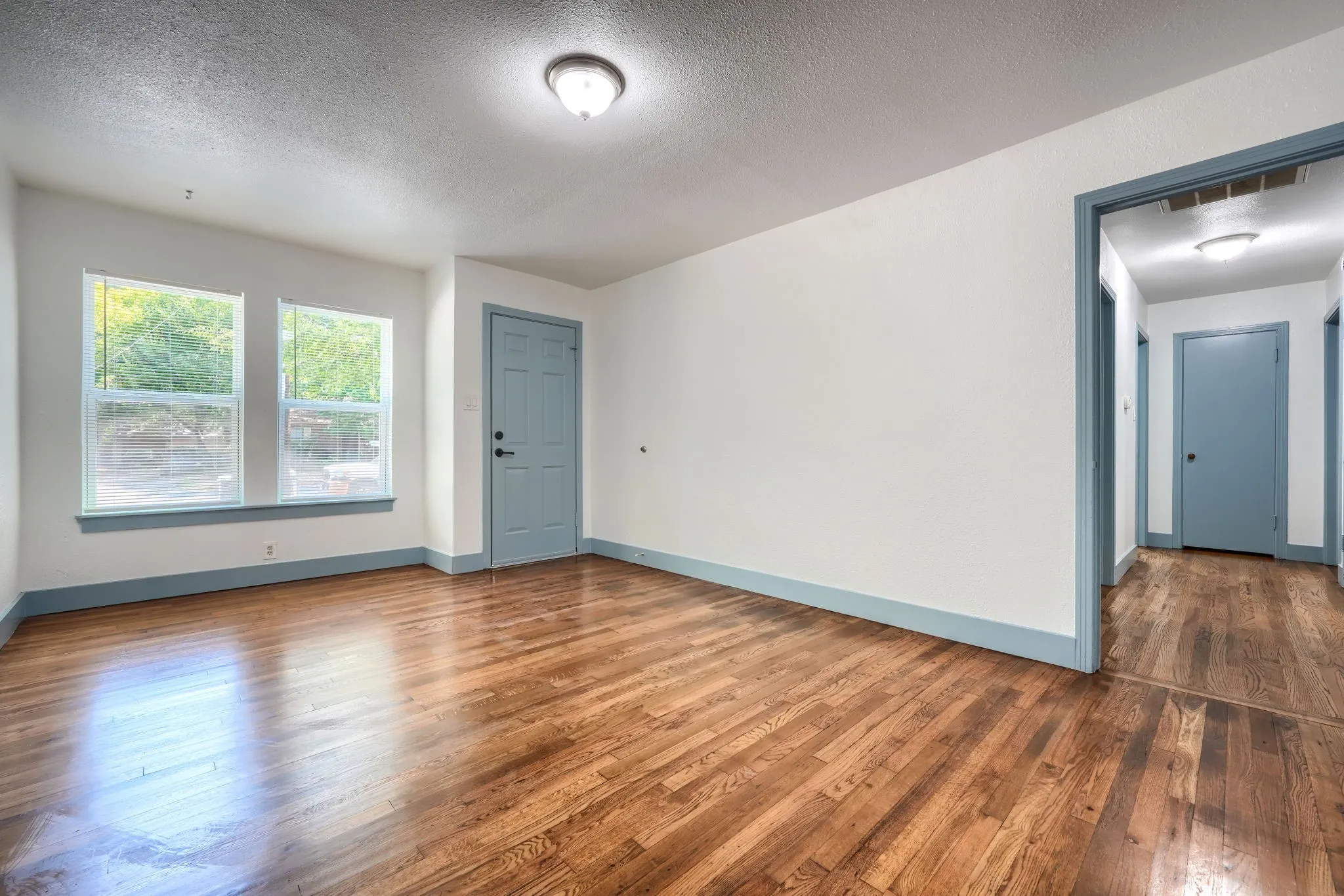 Wood-finish flooring throughout, paired with light-toned walls and contrasting trim