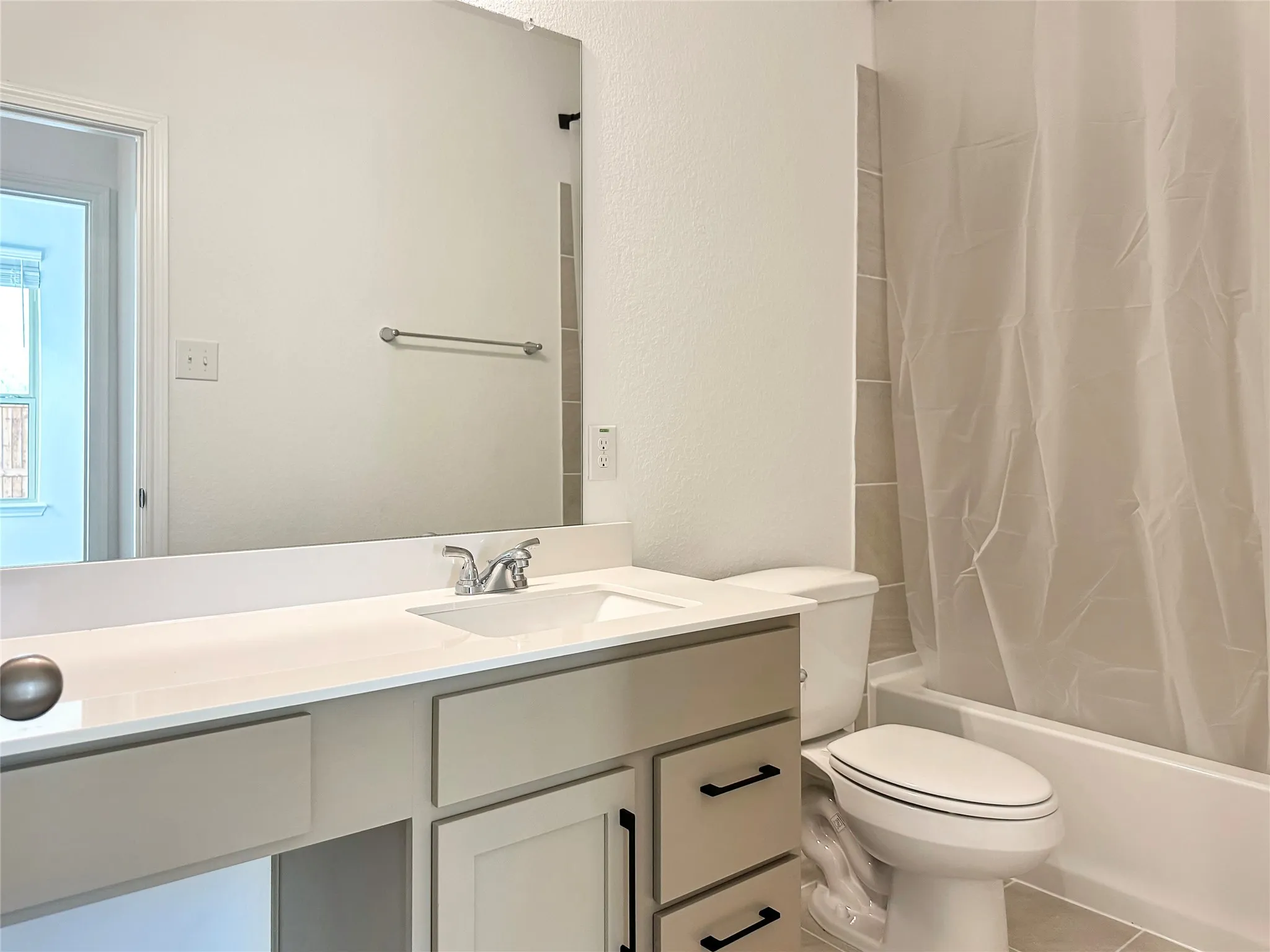 Full bathroom featuring tile patterned flooring, toilet, shower / tub combo, and vanity