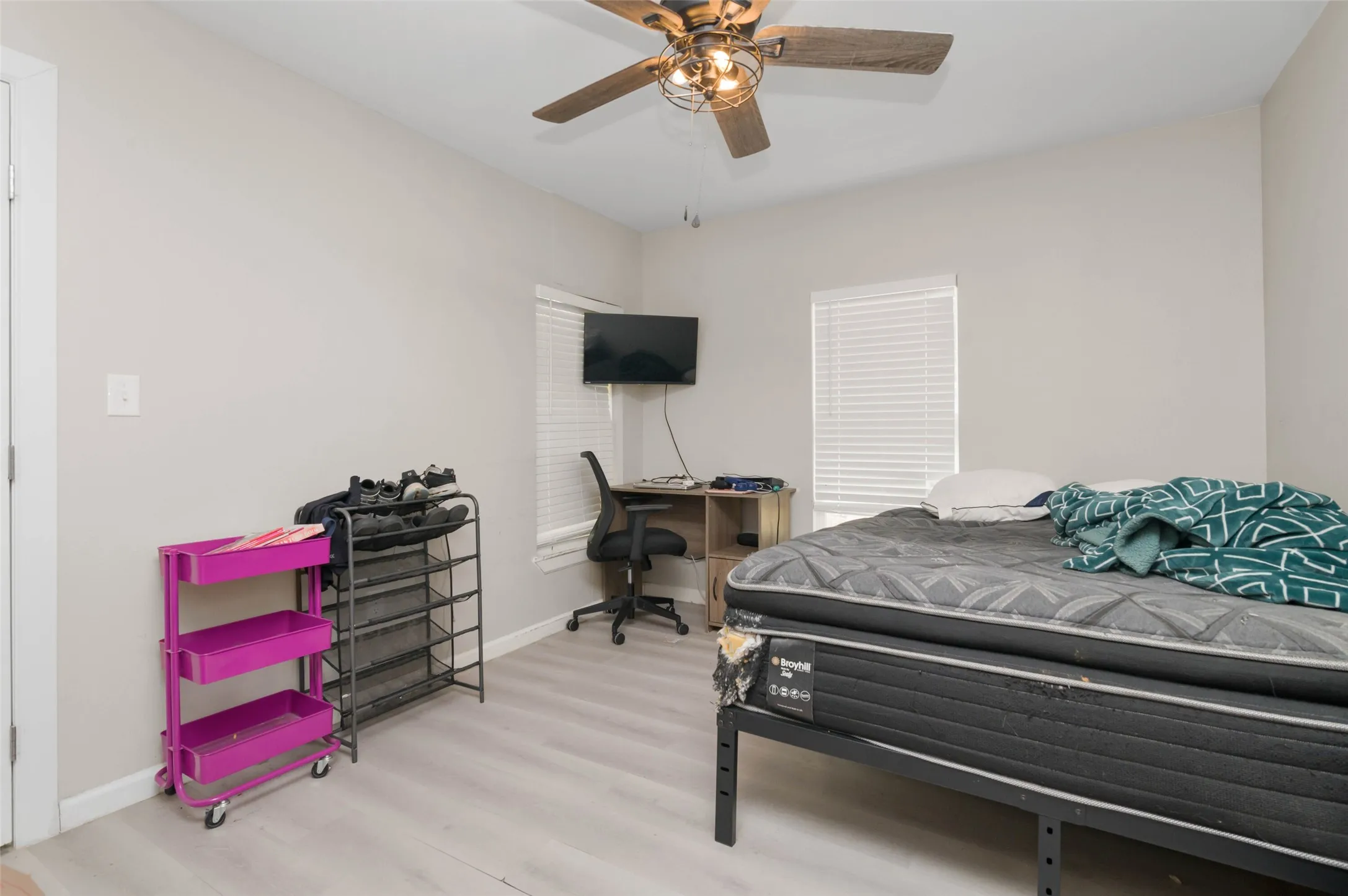 Bedroom with wood finished flooring and ceiling fan.