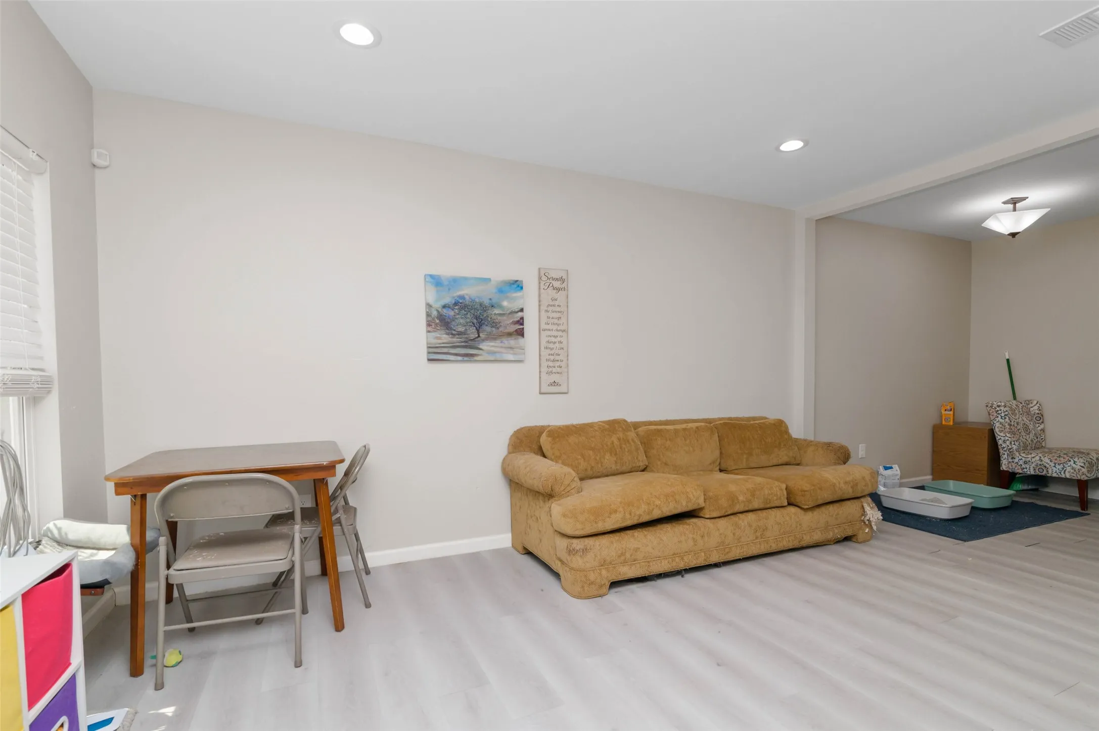Recessed lighting illuminates the neutral wall tones and wood-finish flooring
