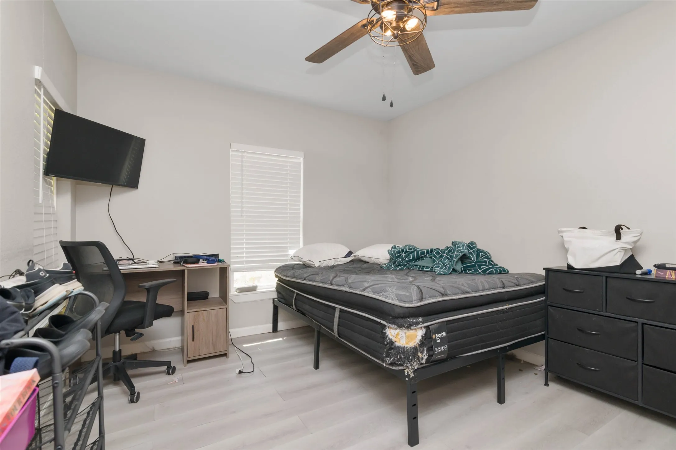 Bedroom with wood finished flooring and ceiling fan.