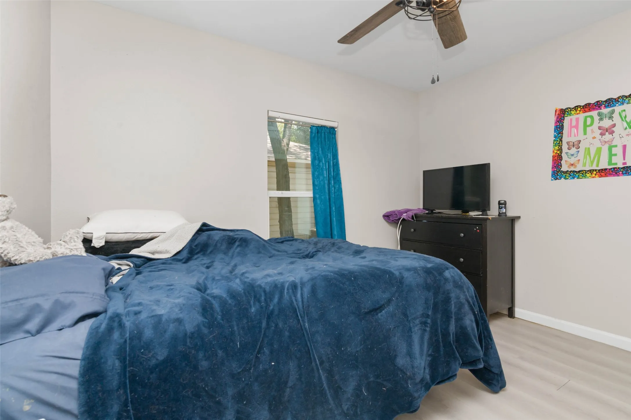Bedroom with wood finished flooring and ceiling fan.