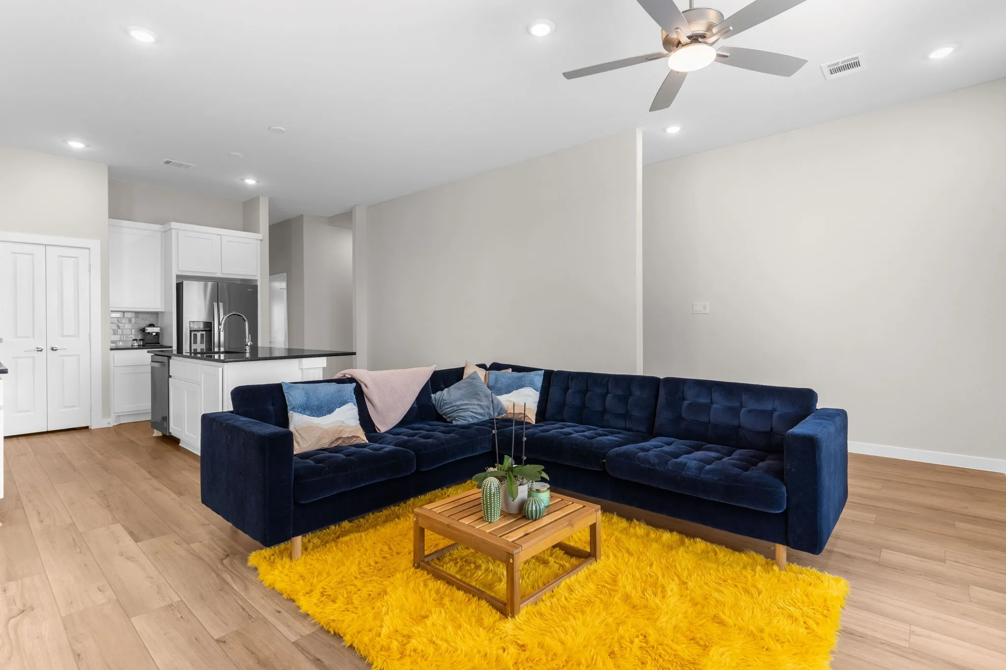 Open-concept living area featuring wood-finish flooring, recessed lighting, and a ceiling fan
