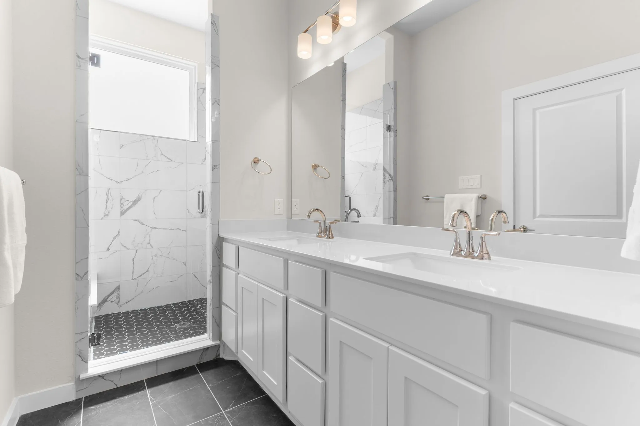 Dual vanity with white shaker-style cabinetry and integrated sinks