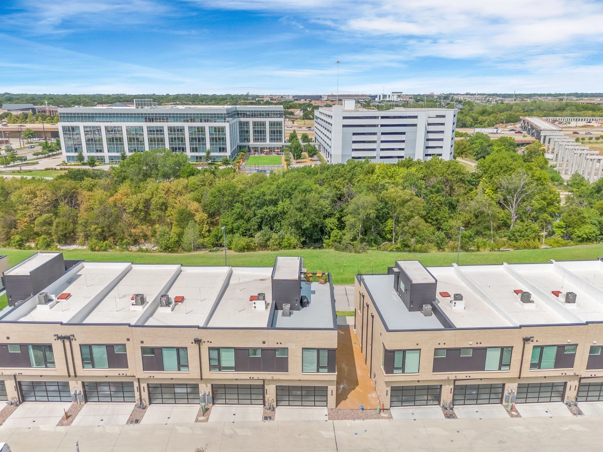 Modern townhome-style residences featuring flat roofs and multiple garage bays