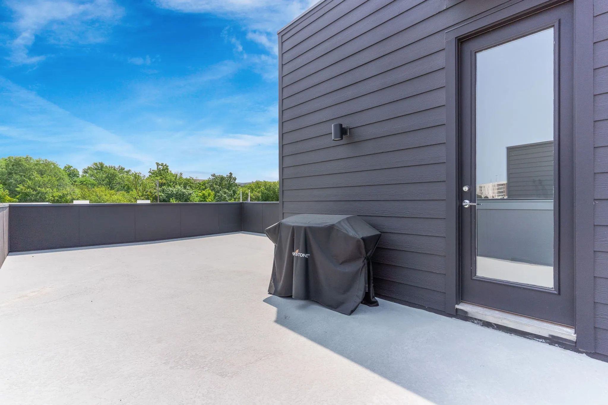 Rooftop deck featuring a full-light exterior door, exterior wall lighting, and horizontal siding