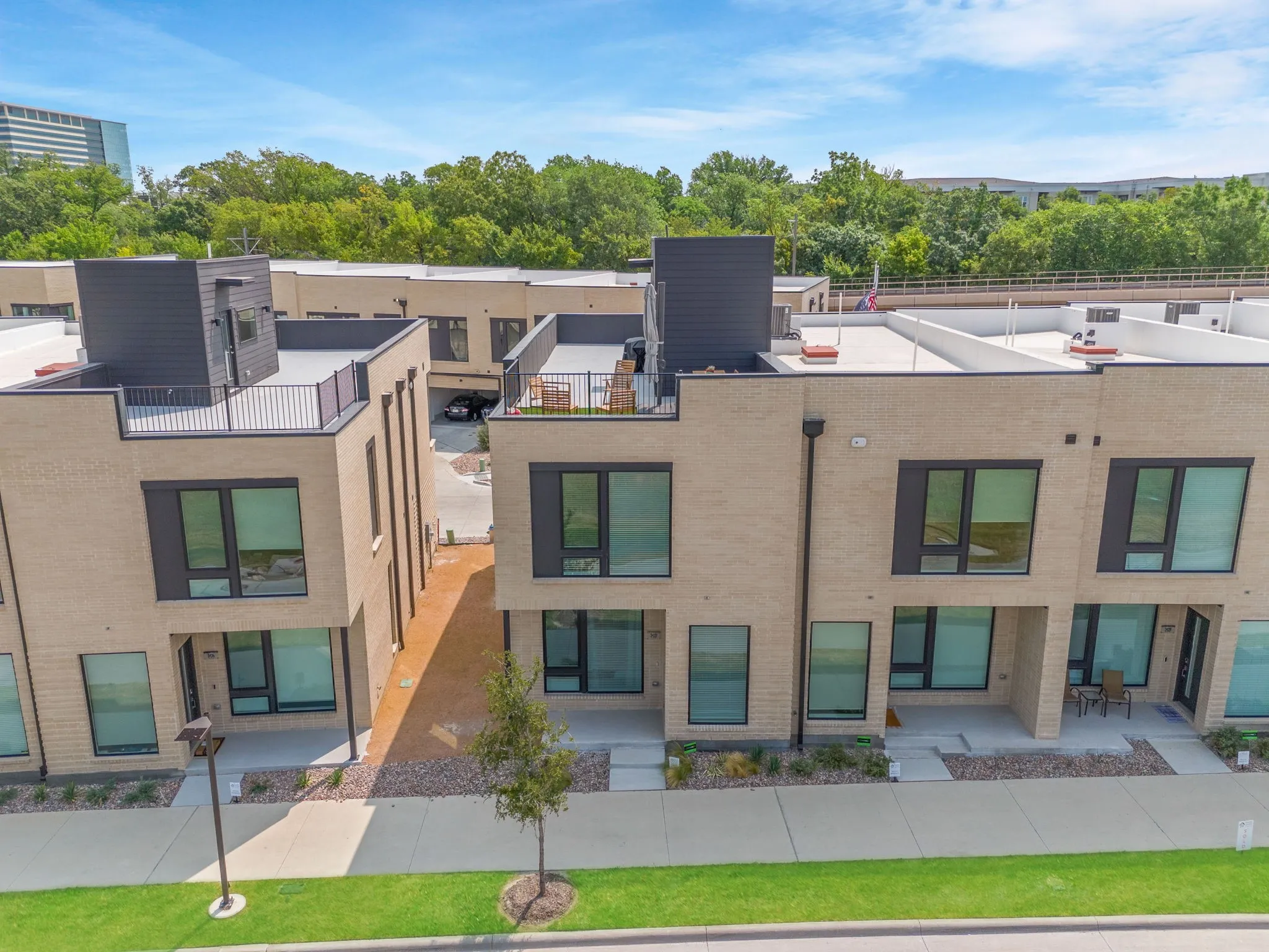 Modern townhomes featuring light-toned brick exteriors and dark-framed windows