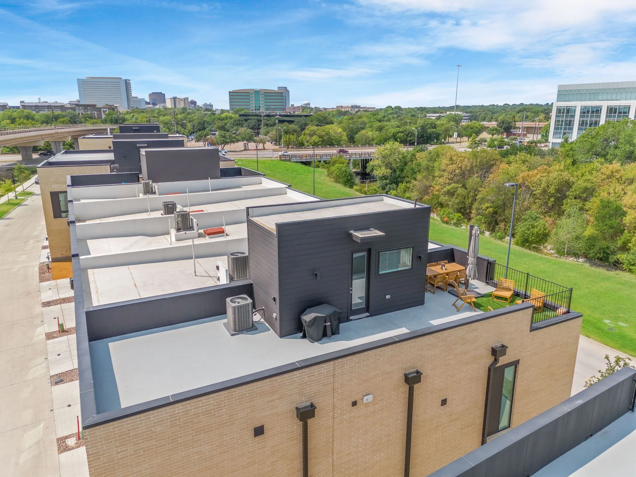 Rooftop deck featuring a privacy wall, integrated artificial turf, and a railing system