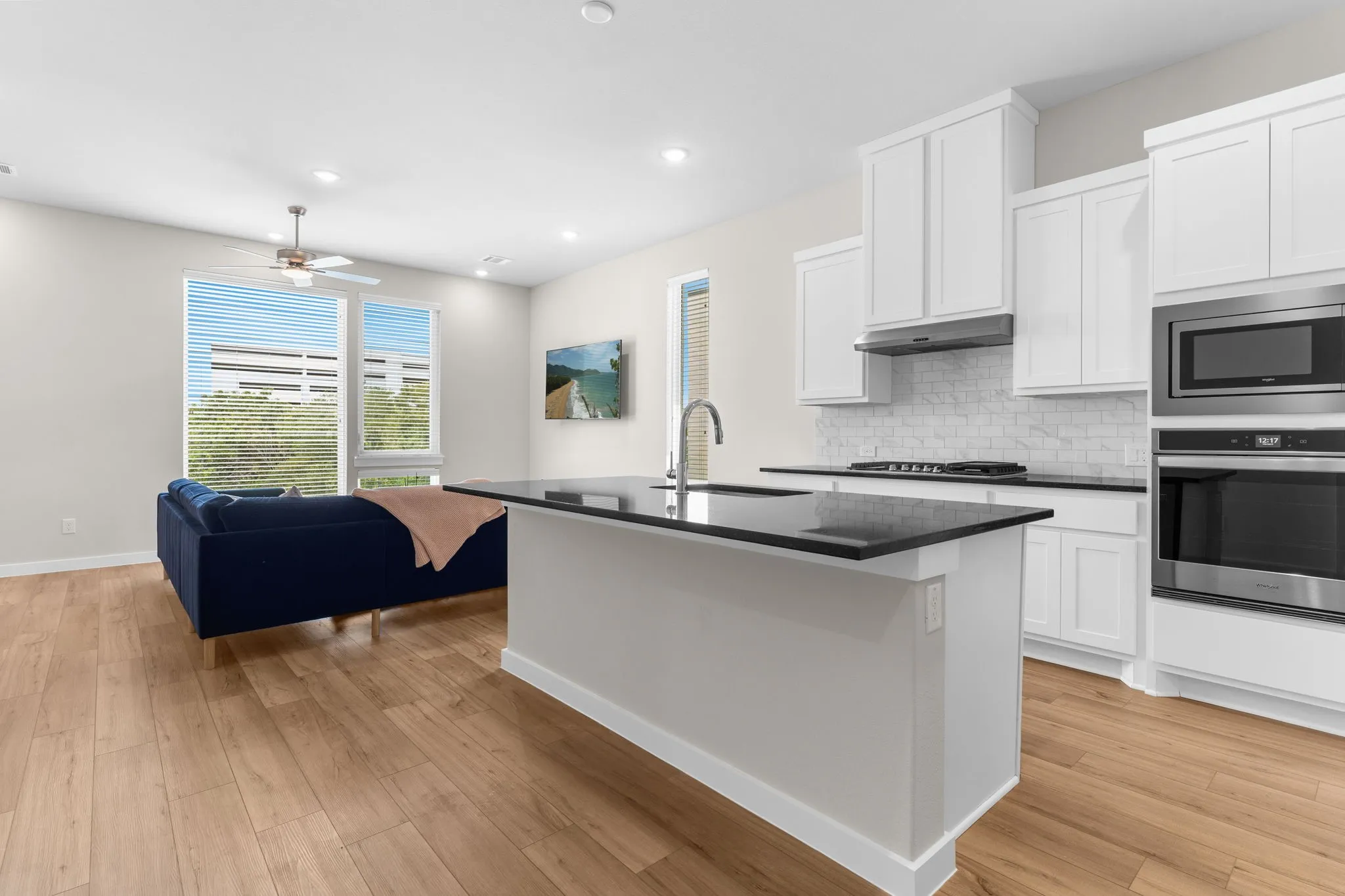 Open-concept living space featuring wood-finish flooring, recessed lighting, and a ceiling fan