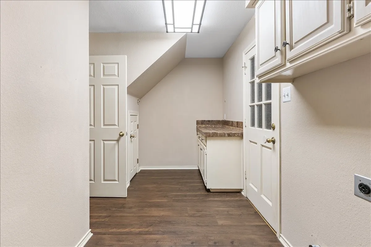 Wood-finish flooring, built-in cabinetry, solid surface countertop, paneled doors, and ceiling-mounted lighting
