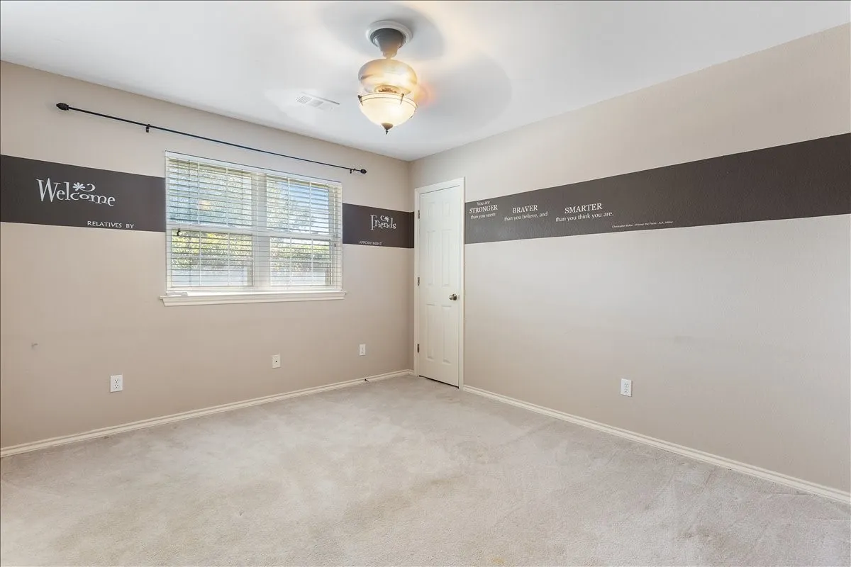 Carpeted flooring, ceiling fan with integrated lighting, single window with blinds, and painted walls