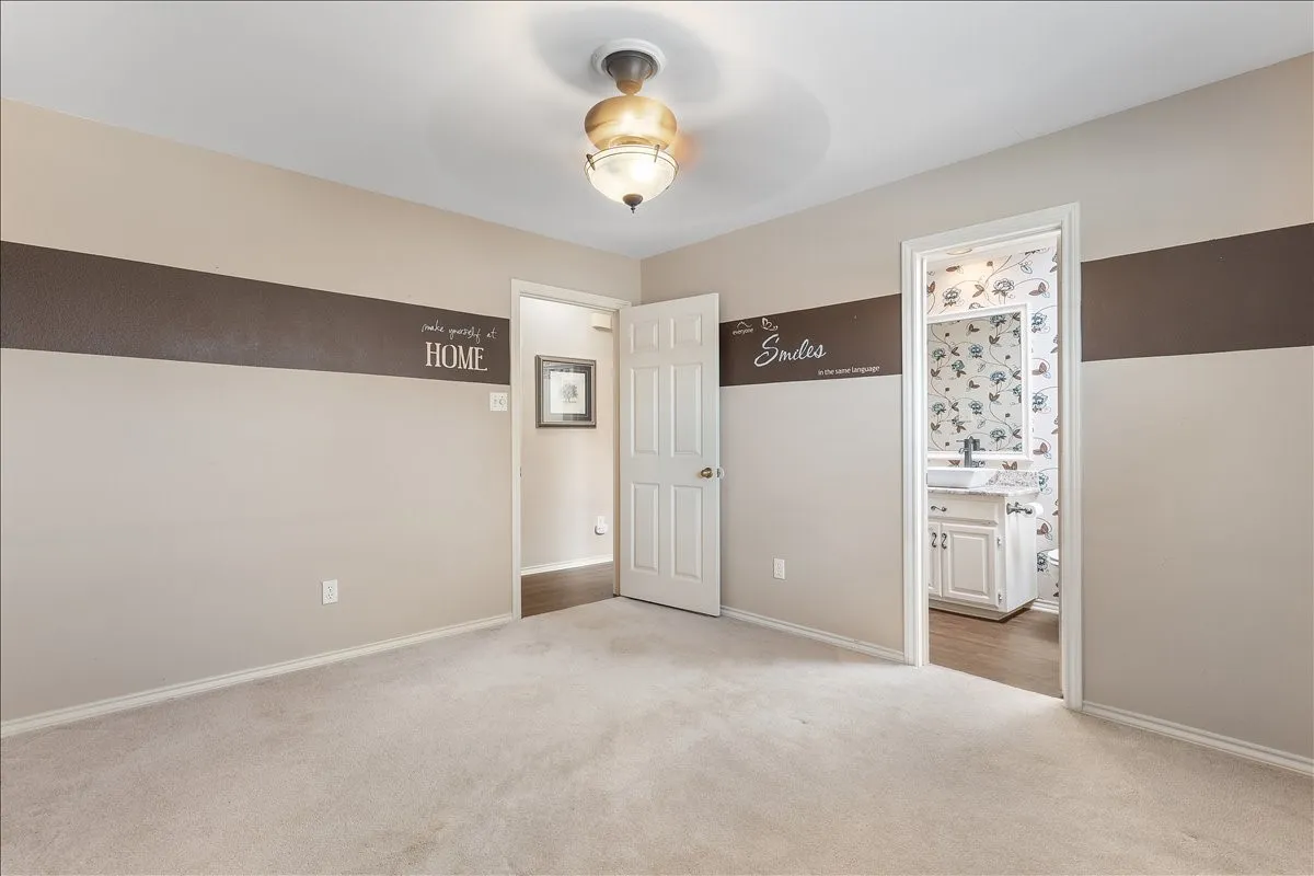 Carpeted room with a ceiling fan light fixture and neutral wall tones