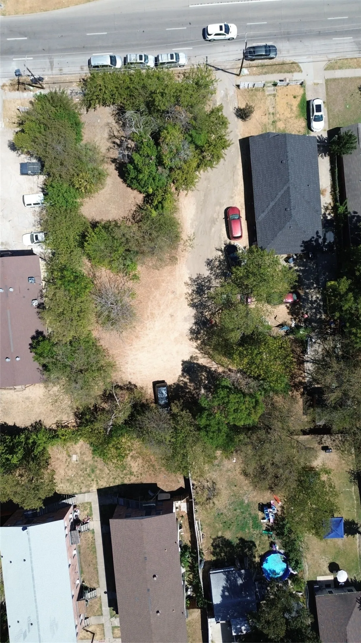 Property featuring a large lot, established trees, and a detached structure with a dark shingle roof