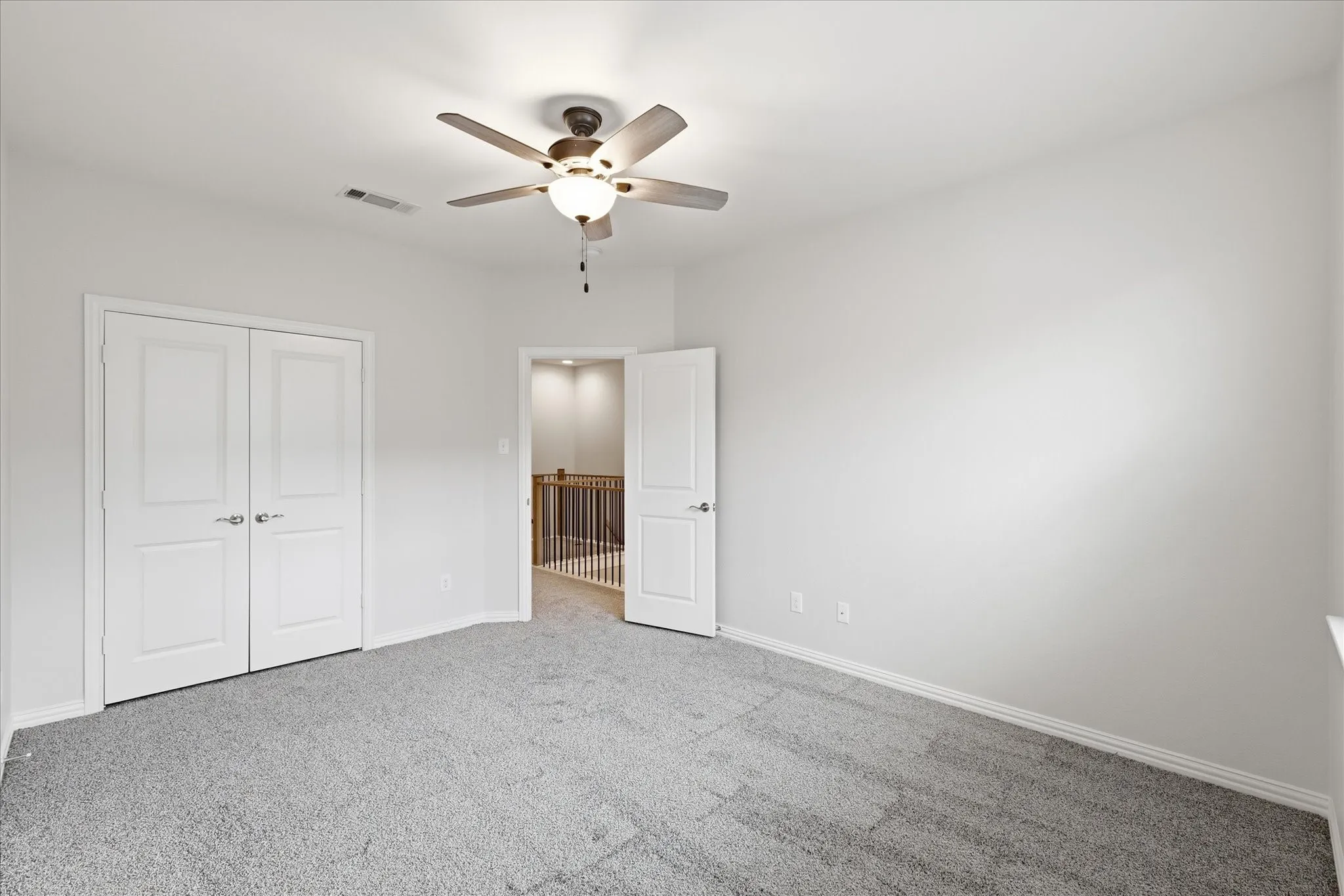 Bright second bedroom with plush carpet and large window. Flexible for guests, office, or nursery