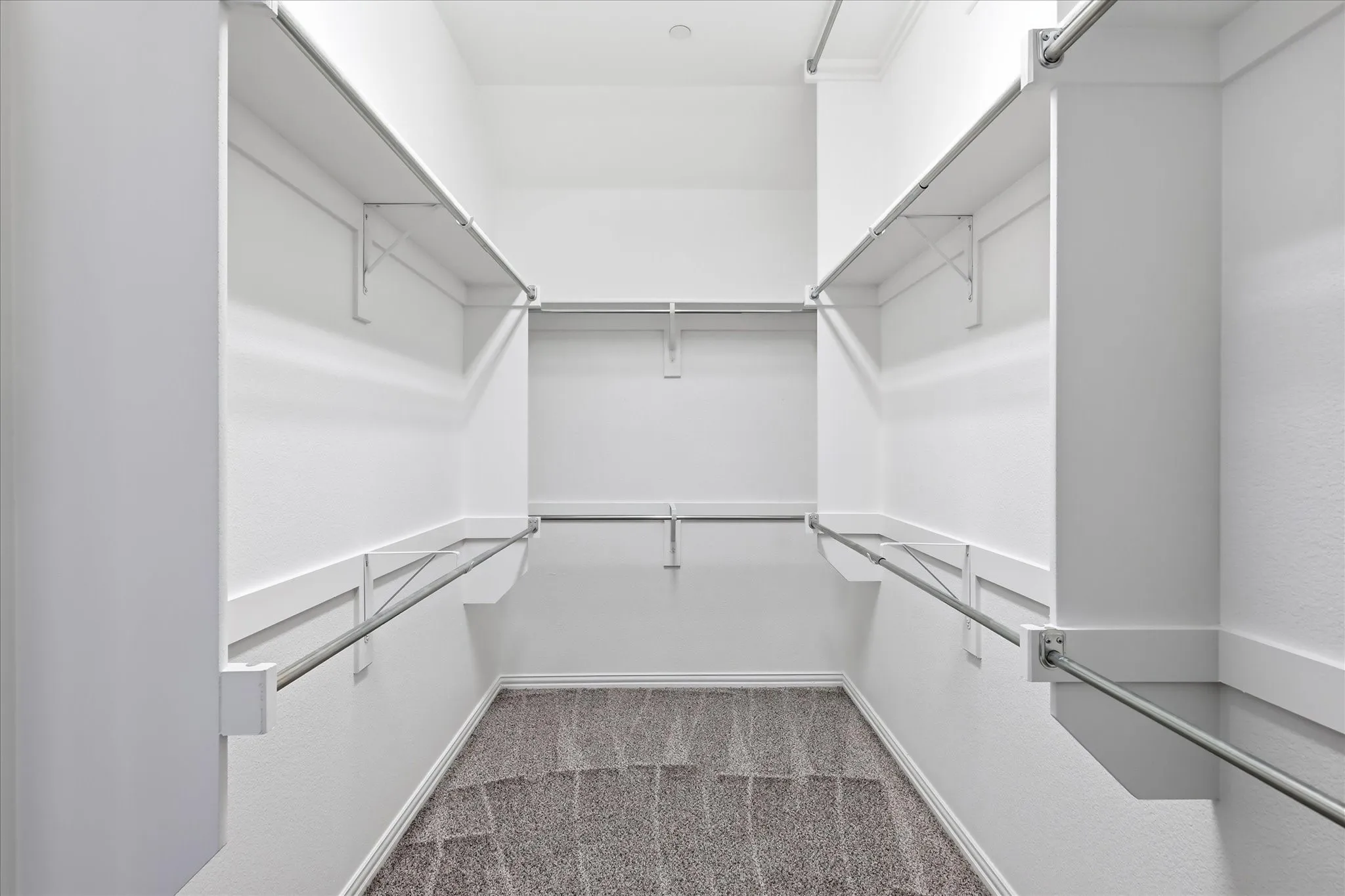 Generous walk-in closet with built-in shelving offers ample storage