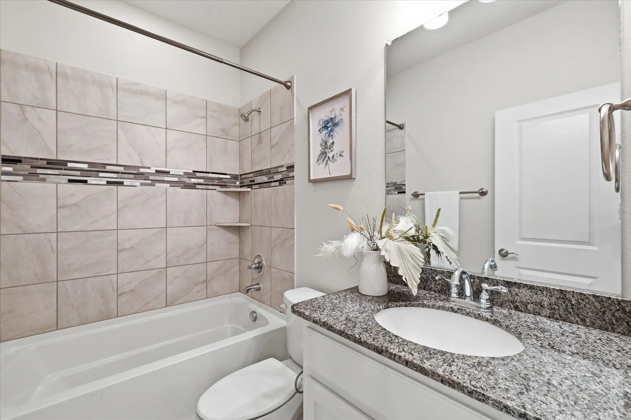 Full secondary bathroom with tub/shower combo and tiled surround