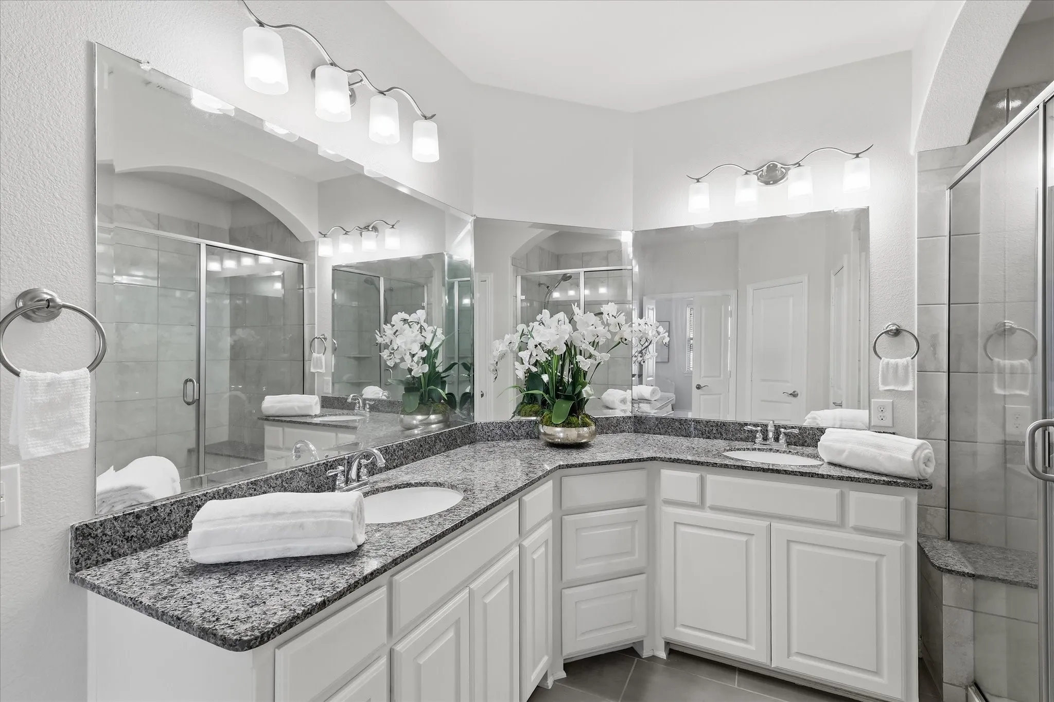 Spa-inspired ensuite bath with dual vanities and granite countertops