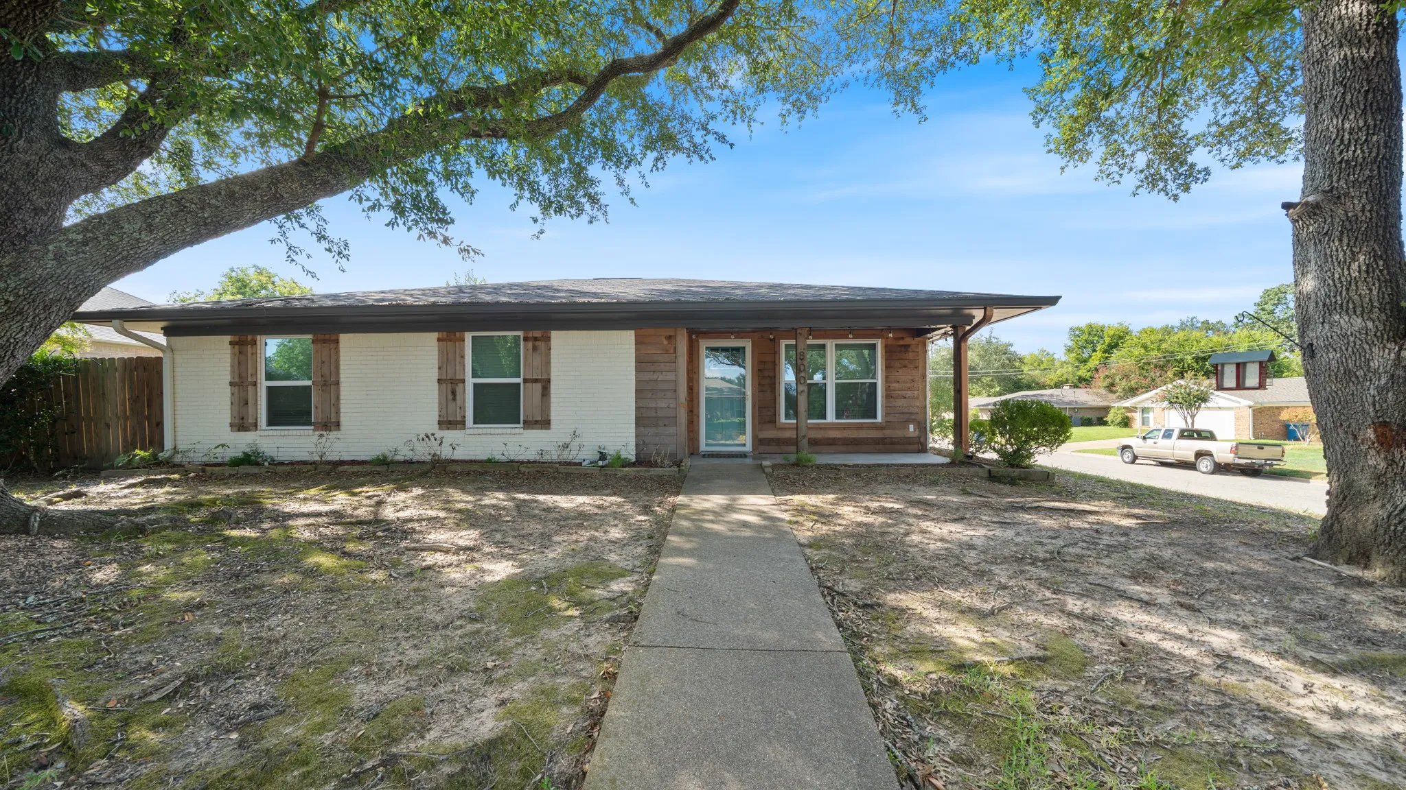 Single-story exterior with white siding and wood-finish accents
