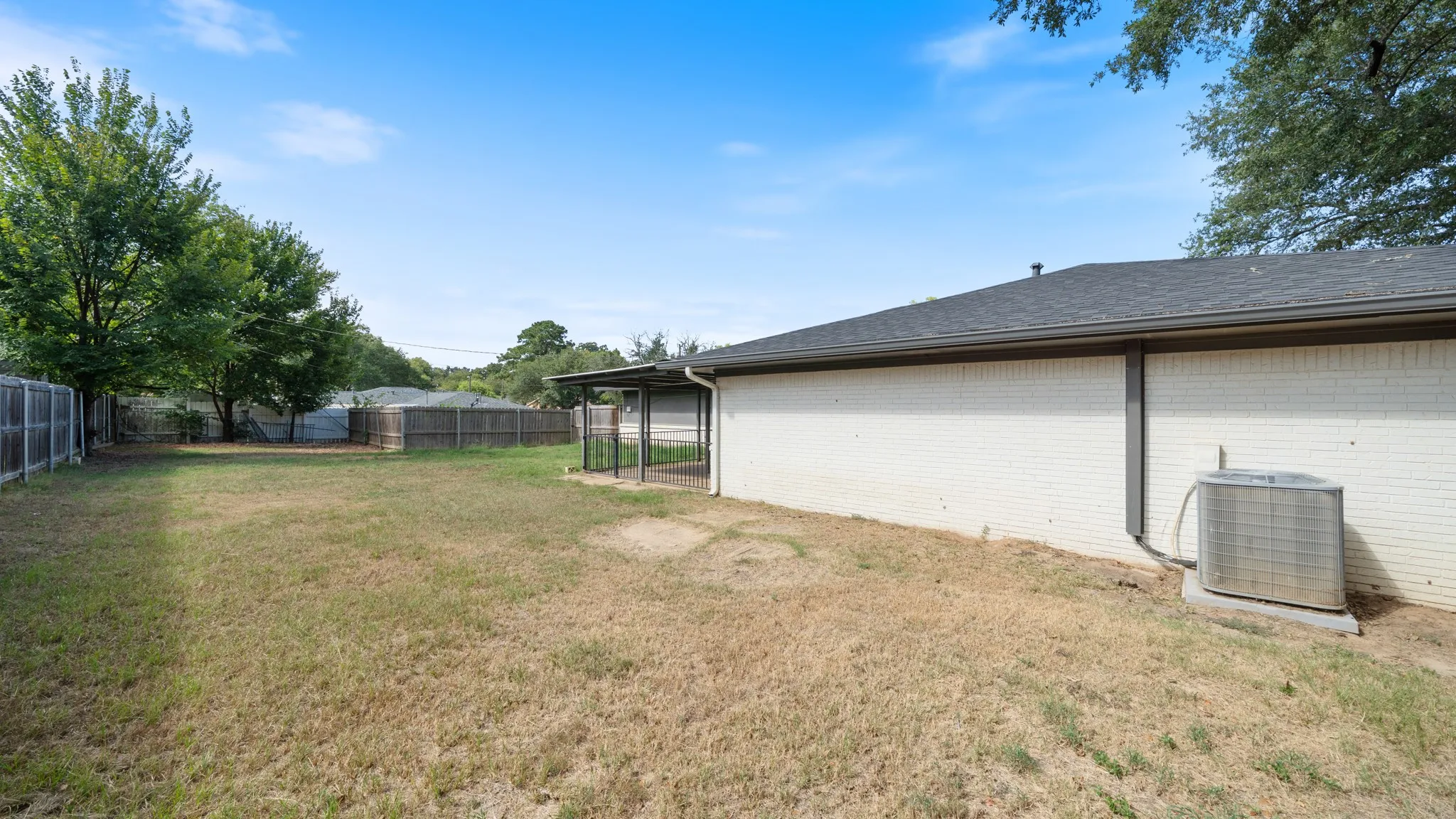 Expansive backyard with wood fencing and mature trees