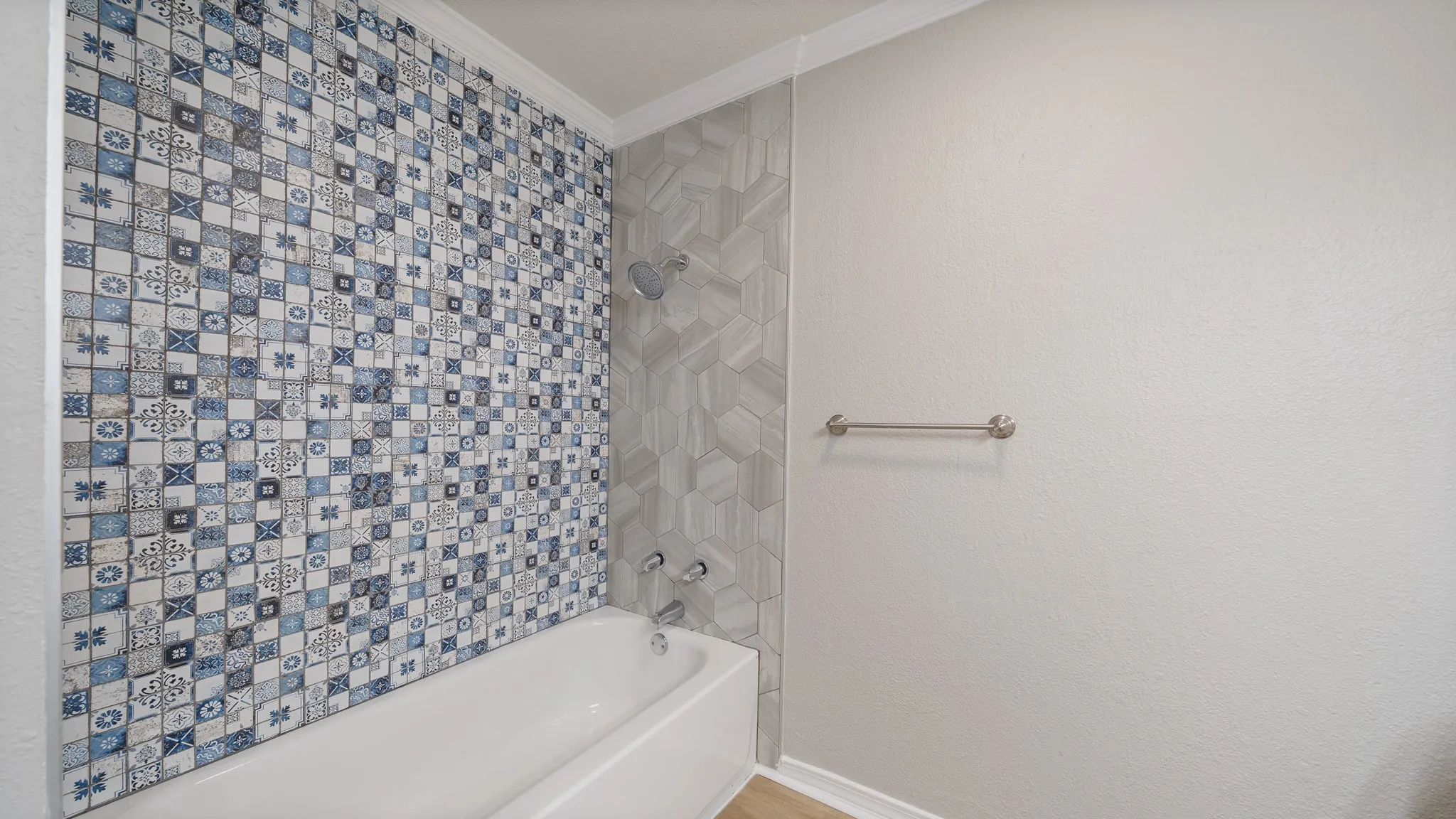 Bathtub with decorative tile surround and chrome shower fixture