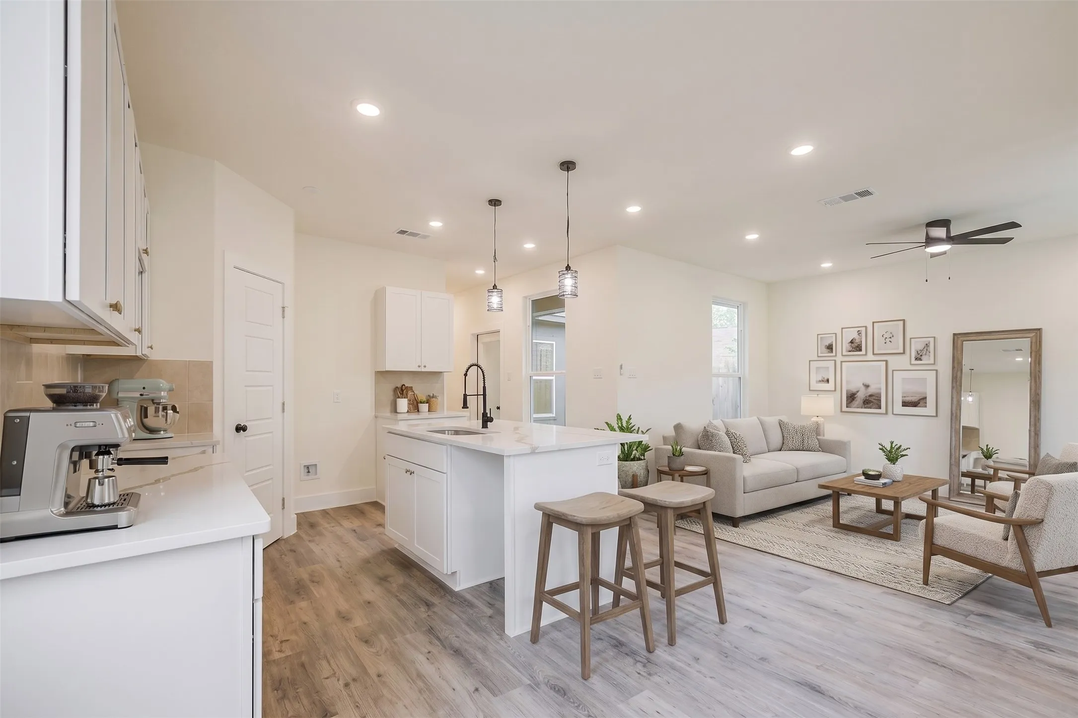 Open-concept living area with wood-finish flooring, recessed lighting, and a ceiling fan
