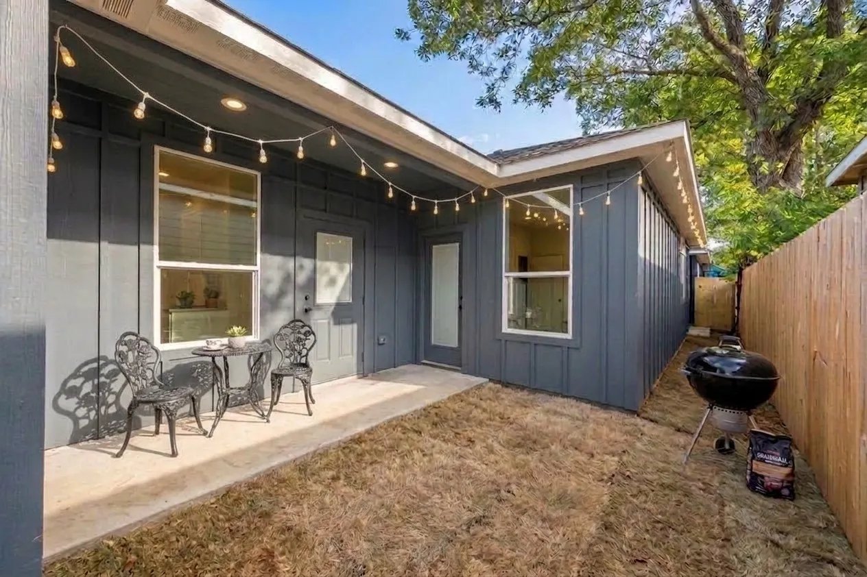Private outdoor patio space featuring a concrete slab and board and batten siding